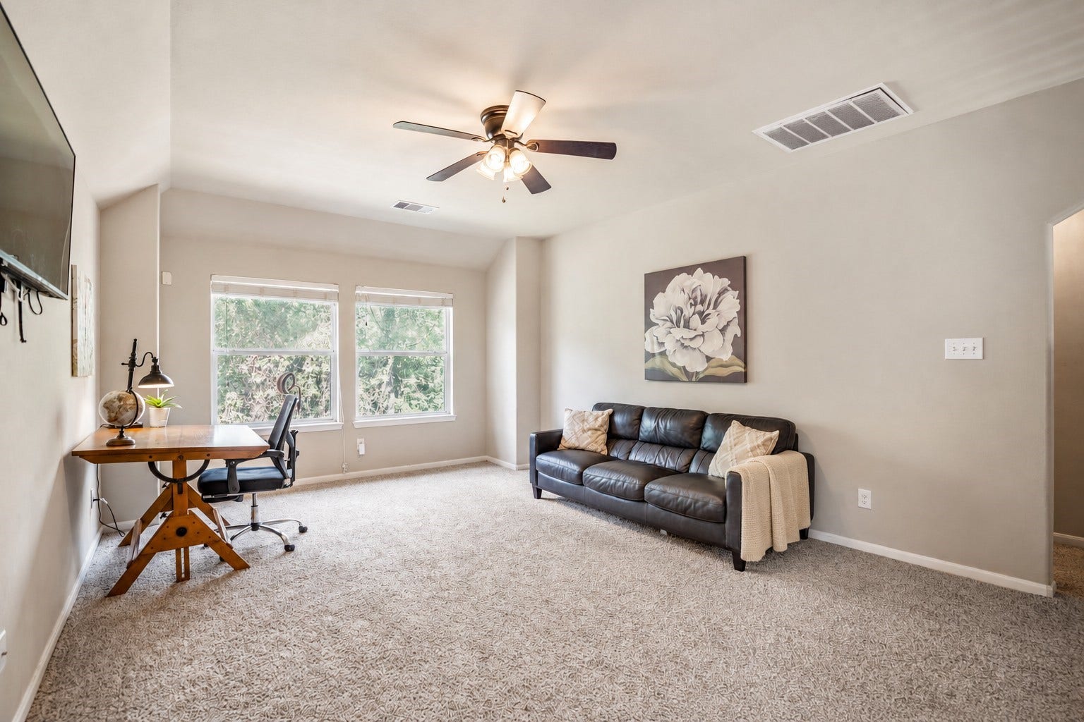 942 Oak Glen Drive, Conroe, TX 77378 At the top of the stairs, the oversized gameroom opens up with plenty of room to spread out for movie nights, playtime, or a second hangout space. Natural light fills the room from the windows ahead, while the arched opening to the right leads to the upstairs full bath well come back to later.