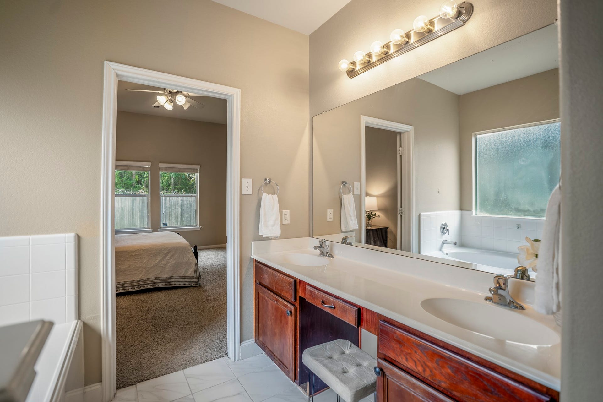 942 Oak Glen Drive, Conroe, TX 77378 This closer look at the primary bath highlights the dual vanity with plenty of counter space, storage below, and a window bringing in natural light. The doorway ahead leads back into the primary bedroom, keeping the suite easy to navigate while giving the bath its own defined space.