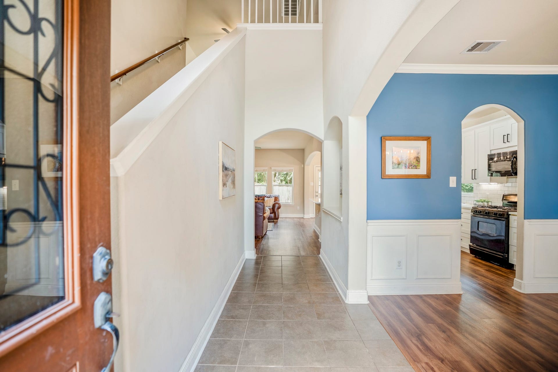 942 Oak Glen Drive, Conroe, TX 77378 Step inside to a bright entry with the staircase immediately to the left and the formal dining room opening to the right. The upper bannister gives you a glimpse of the second floor, while the hallway ahead leads deeper into the home toward the kitchen, breakfast area, and living room.
