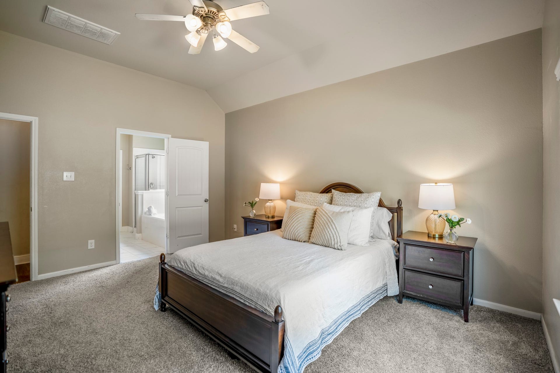 942 Oak Glen Drive, Conroe, TX 77378 This angle gives you a better feel for the primary bedrooms size, with room for nightstands on both sides and extra furniture without crowding the space. The doorway on the left leads into the primary bath, keeping everything close at hand while the bedroom itself still feels calm and separate from the main living areas.