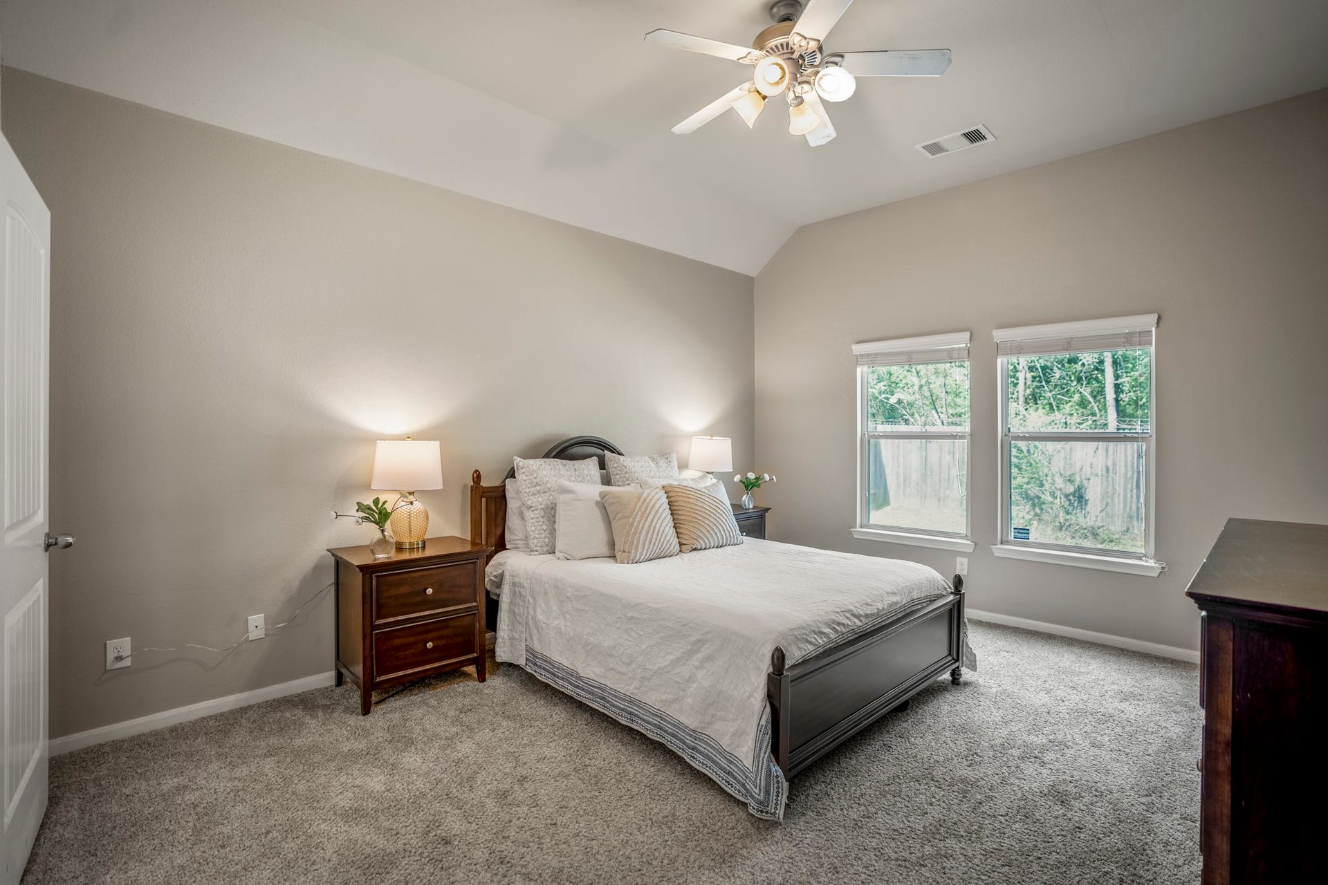 942 Oak Glen Drive, Conroe, TX 77378 The downstairs primary bedroom offers a quieter place to unwind, with new carpet underfoot and a large window bringing in natural light and backyard views.