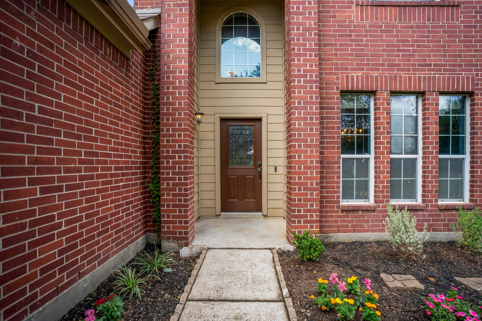 942 Oak Glen Drive, Conroe, TX 77378 Two-story brick arch detail gives the covered front porch a strong sense of arrival, while siding surrounds the front door and transom window above. Tall front windows nearby bring extra architectural interest and hint at the natural light waiting inside.