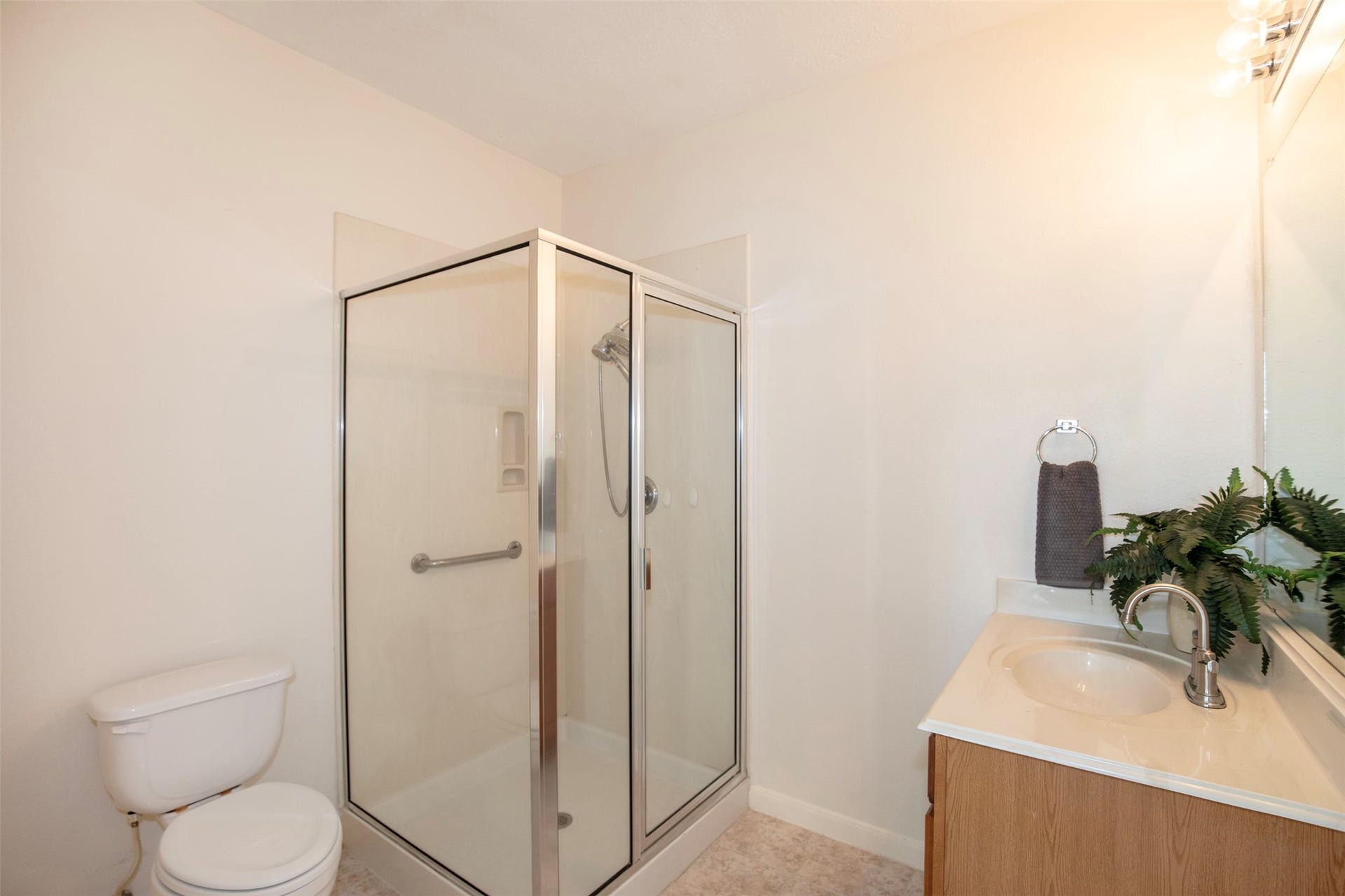 3612 Fir Hollow Way, Pearland, TX 77581 Private ensuite bath includes an accessible walk-in shower with grab bar, convenient layout, and direct access from the first-floor suite and walk-in closet.