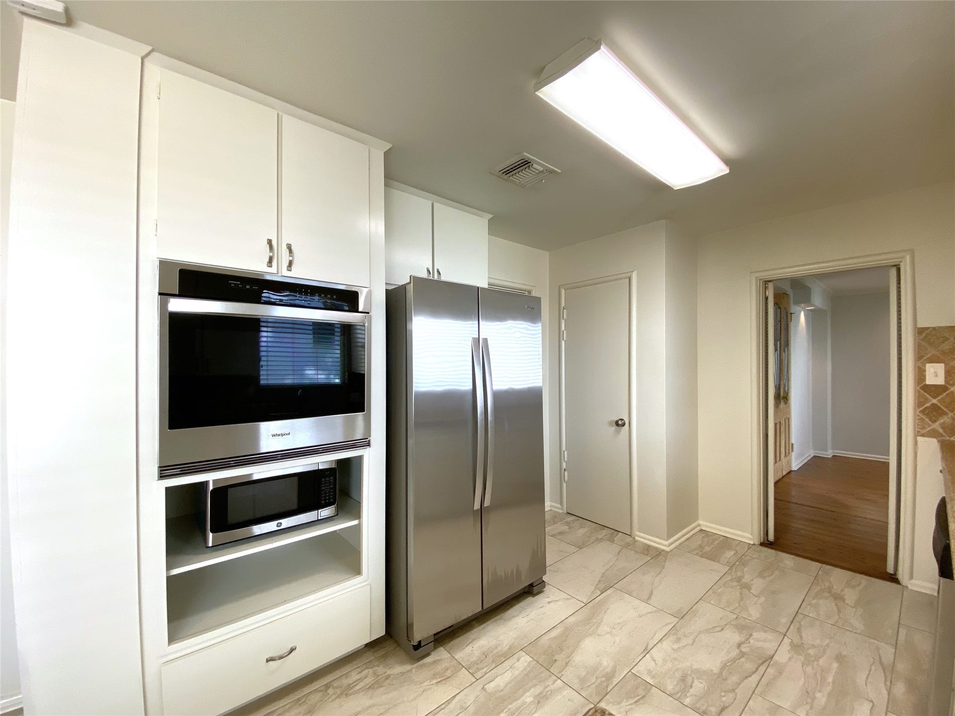 3207 Banbury Place, Houston, TX 77027 Behind the door to the right of the refrigerator is a pantry.