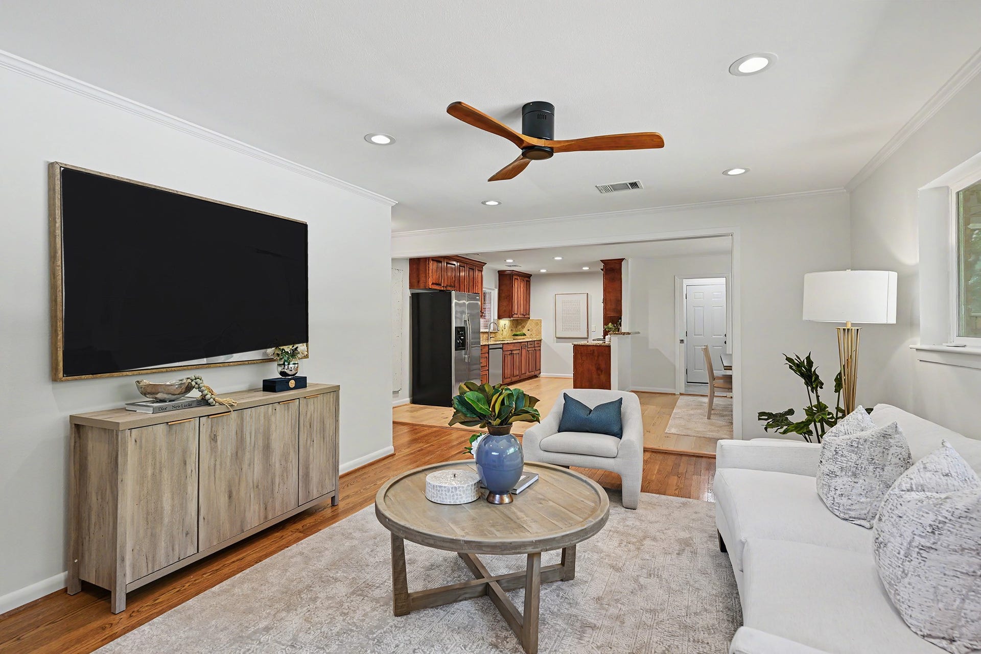 Spacious living room with hardwood floors and great natural light, open to kitchen and dining areas