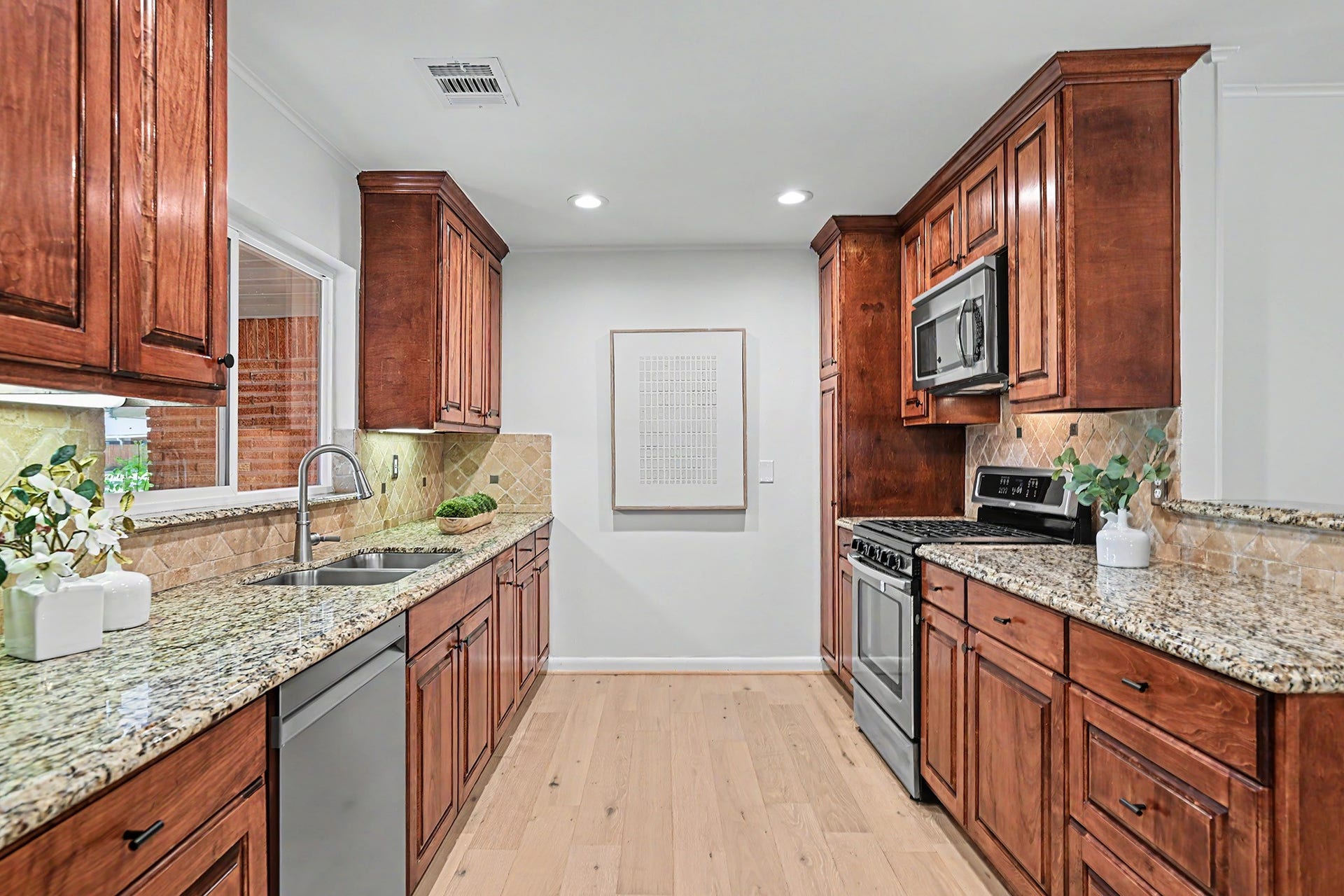 Open kitchen with stainless steel appliances and engineered wood floors