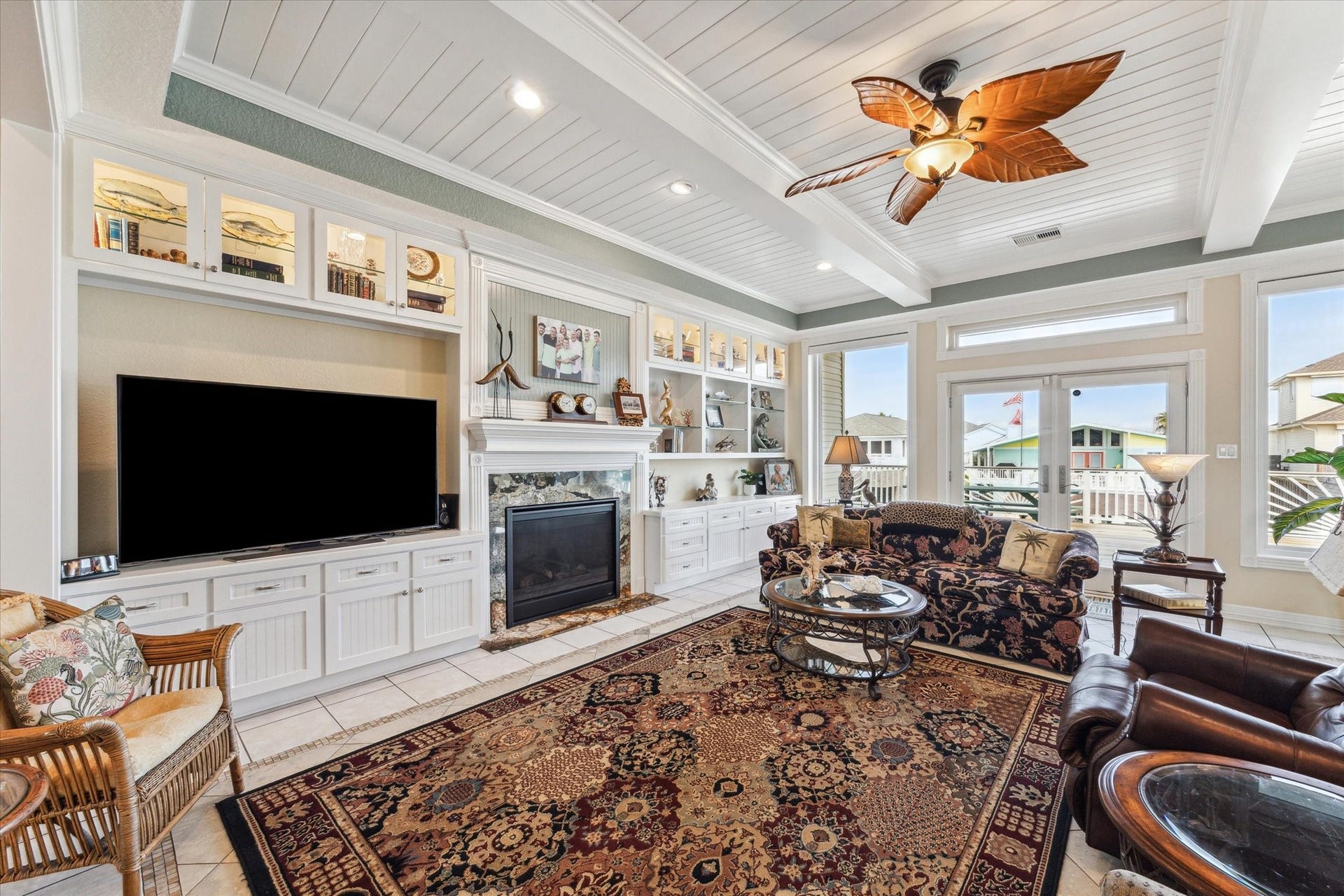 102 Bamaku Bend, Tiki Island, TX 77554 The beautiful custom cabinetry in the living room offers lighted glass door cabinets at the top and plenty of storage space below. The custom gas fireplace is highlighted with fluted trim & rosettes, a granite surround & mantle with beadboard accent wall.