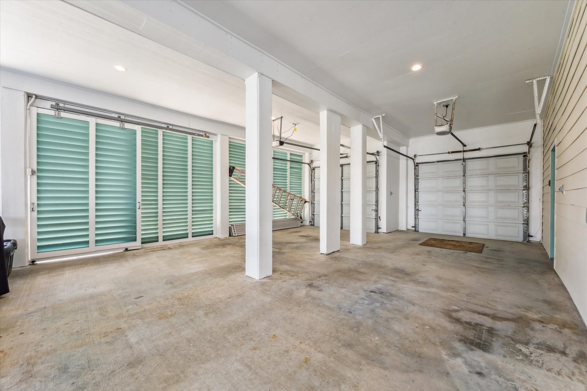 102 Bamaku Bend, Tiki Island, TX 77554 Plenty of space to park in these two garage spaces! Both garage door openers have been recently replaced. Plus one of the louvre screens slides to provide access to the lift to the second level deck.