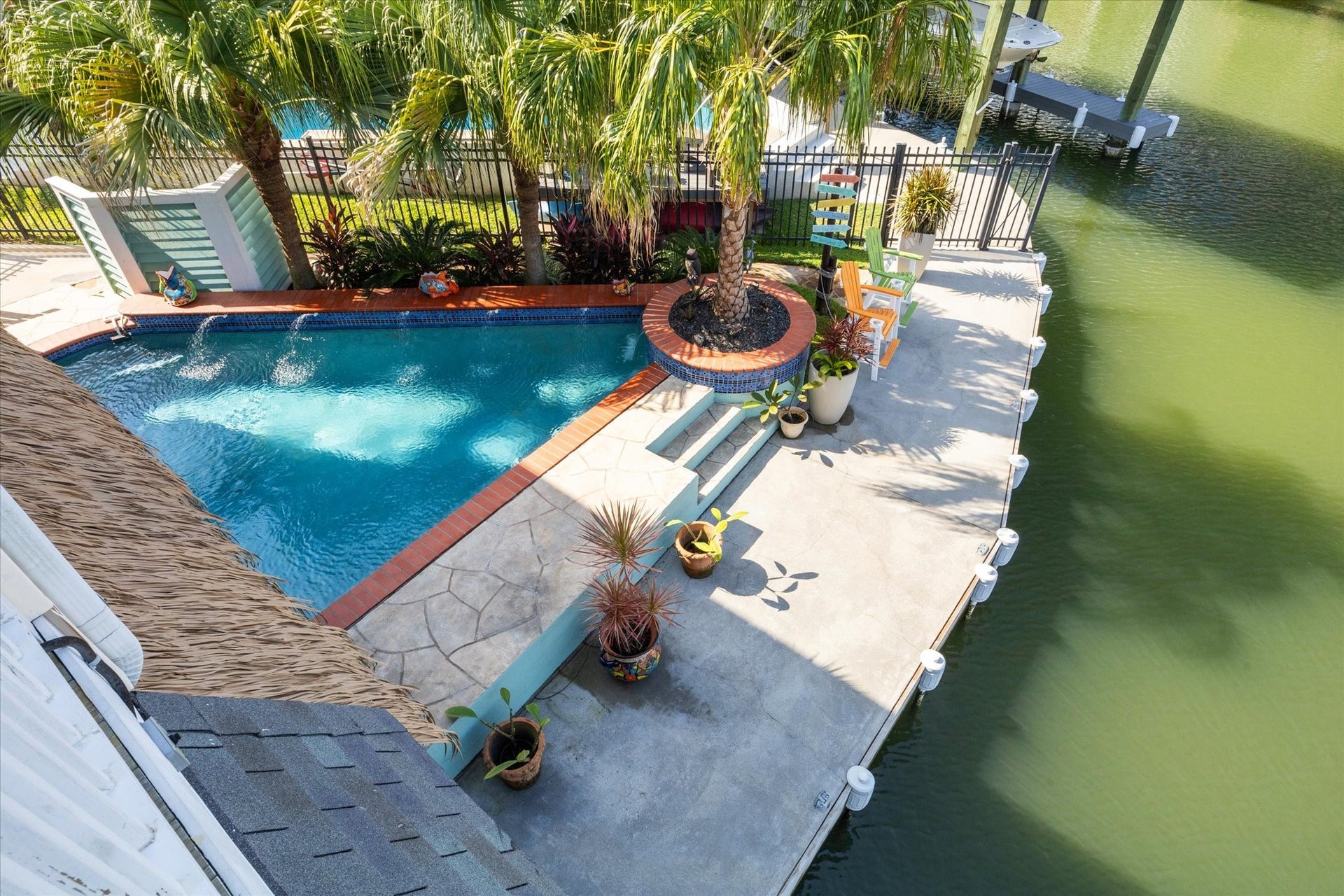 102 Bamaku Bend, Tiki Island, TX 77554 This view from your second level deck shows the corner pool overlooking the canal, along with an additional seating area along the 118' of concrete bulkhead. There is plenty of boat parking if you need more than your 2 boat slips and multiple outdoor areas to enjoy!