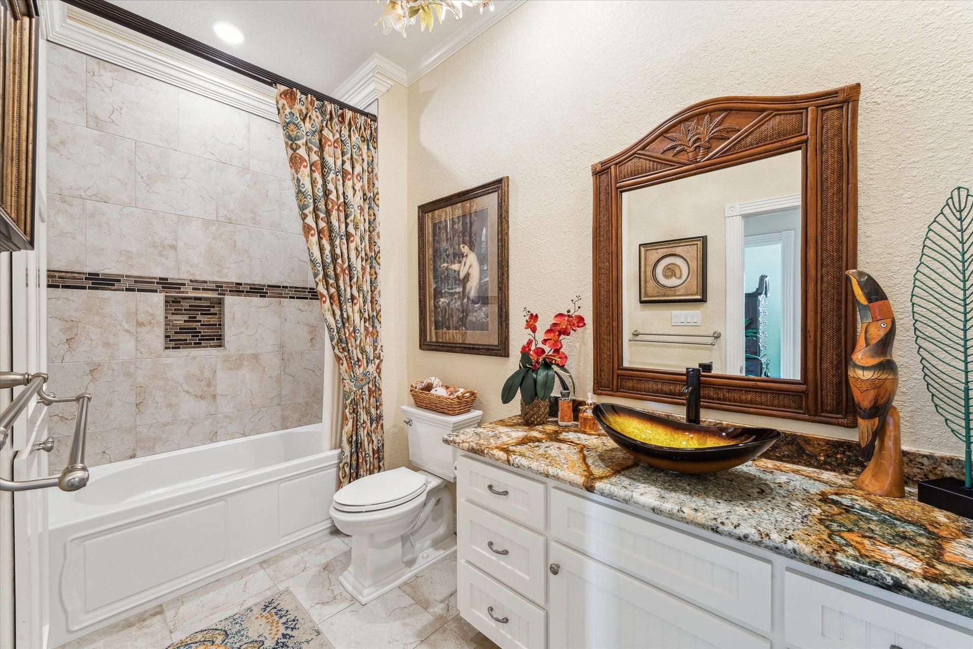102 Bamaku Bend, Tiki Island, TX 77554 The updated guest bath provides a large vanity with vessel sink, updated tile floors & shower stalls, a Kohler tub with custom shower curtain, toilet with soft close lid & new plumbing fixtures. There is additional storage space in the linen closet.