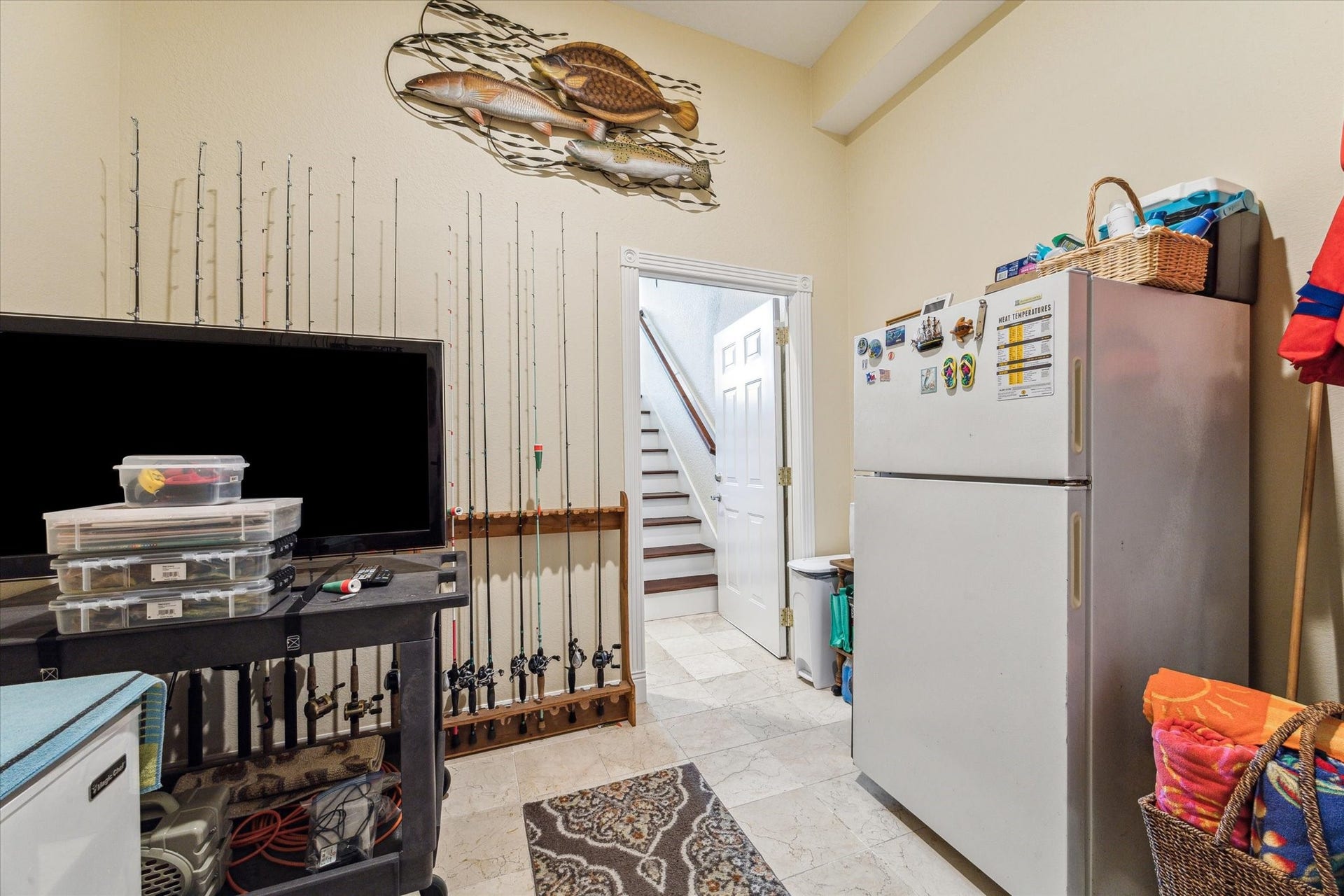 102 Bamaku Bend, Tiki Island, TX 77554 As you head down stairs you have a large storage room under the stairs, access into the garage and this room which offers a great space to store all of your fishing and water sport toys and supplies.
