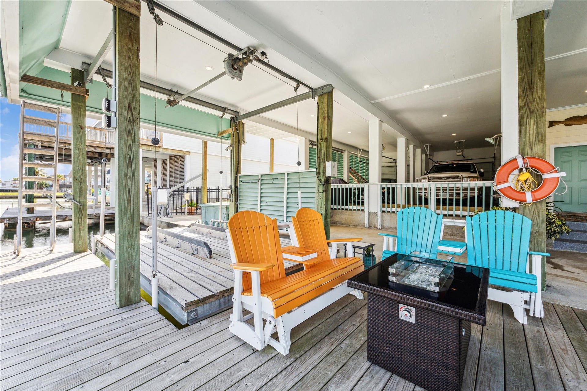 102 Bamaku Bend, Tiki Island, TX 77554 There is no lack of entertaining space or opportunities to enjoy your waterfront views. In between the two boat lifts the owners have created this firepit area. There is also a custom retractable stairway at the end of the deck to make getting in and out of the canal easy.