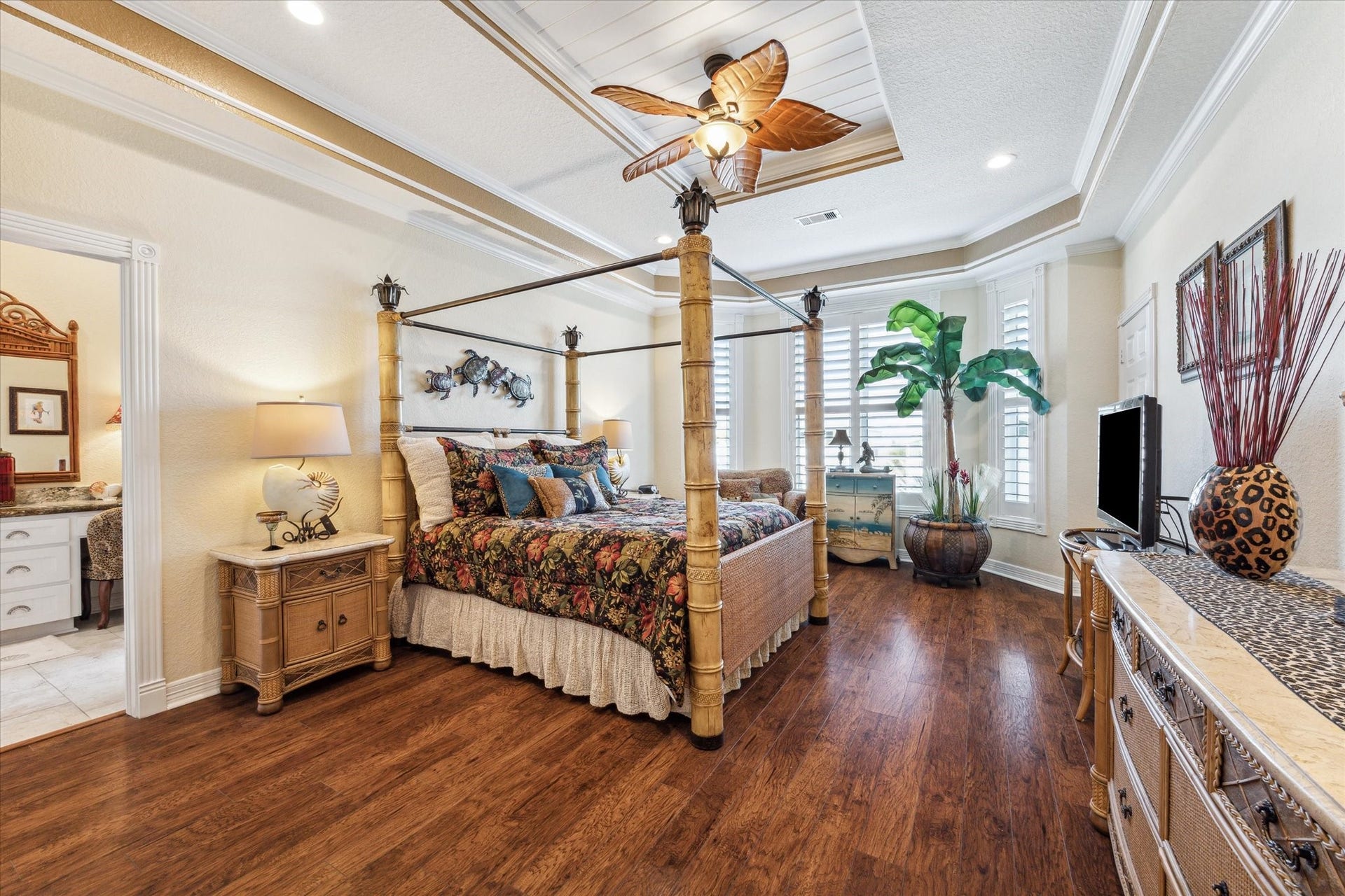 102 Bamaku Bend, Tiki Island, TX 77554 The spacious Primary Bedroom has plenty of room for all of your furniture and boasts beautiful wood floors, bay windows with plantation shutters that overlook the back deck and water, beadboard tray ceiling, crown molding and detailed trim work.