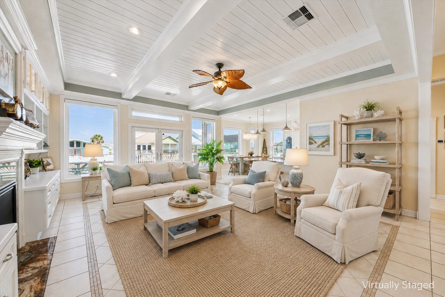102 Bamaku Bend, Tiki Island, TX 77554 As you enter the elegant, coastal inspired living area (virtually staged in this photo) you are immediately drawn to the wall of windows and French doors leading out to the massive deck overlooking the canal. The beadboard ceiling, beams and extensive trim and molding add to the design.