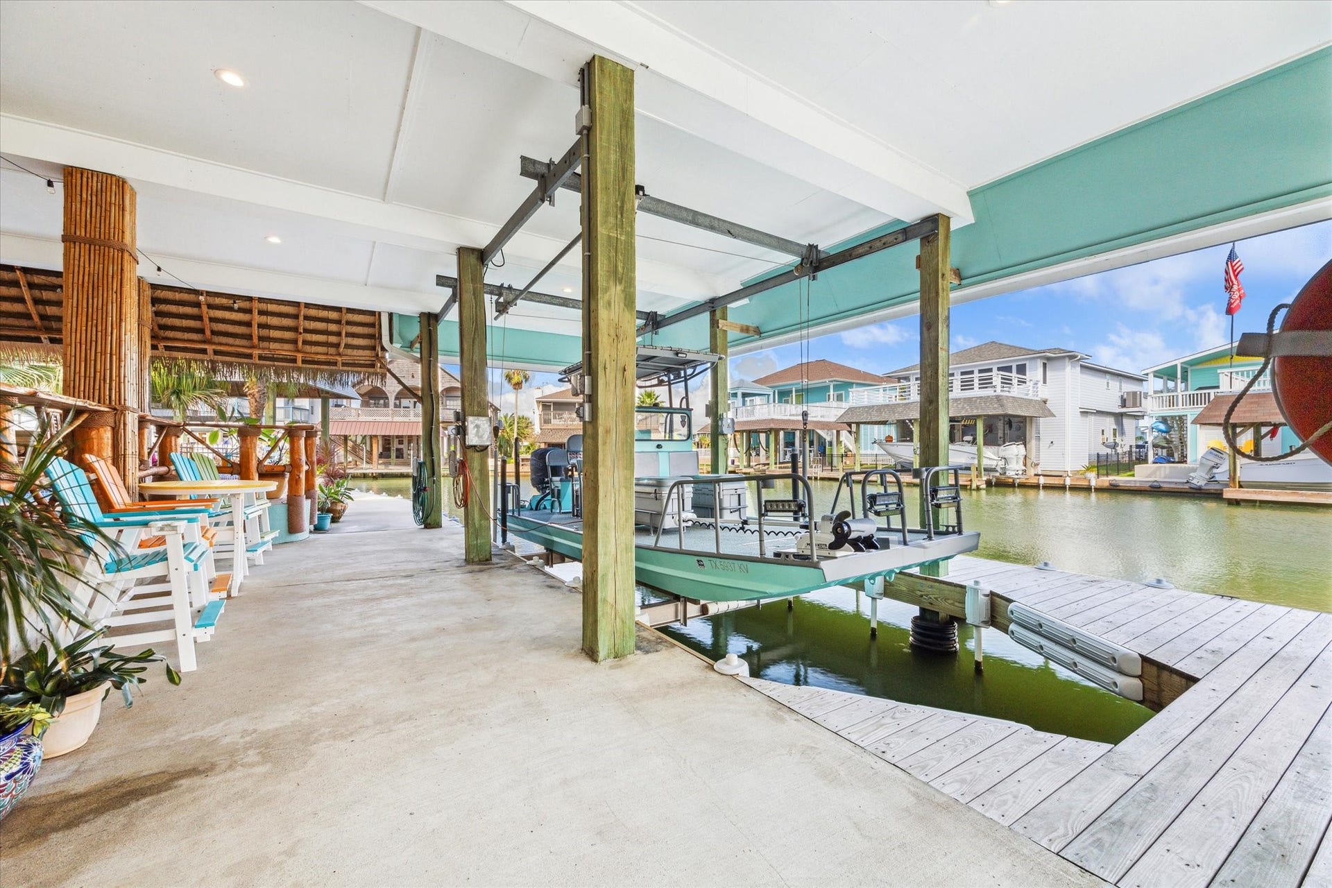102 Bamaku Bend, Tiki Island, TX 77554 This is one of the two boat slip with bumpers and lift. It can easily accommodate this 22 foot boat with plenty of room for a larger boat! You can also sit and enjoy the water views down here because the decking above was sealed and finished with Hardie Board.