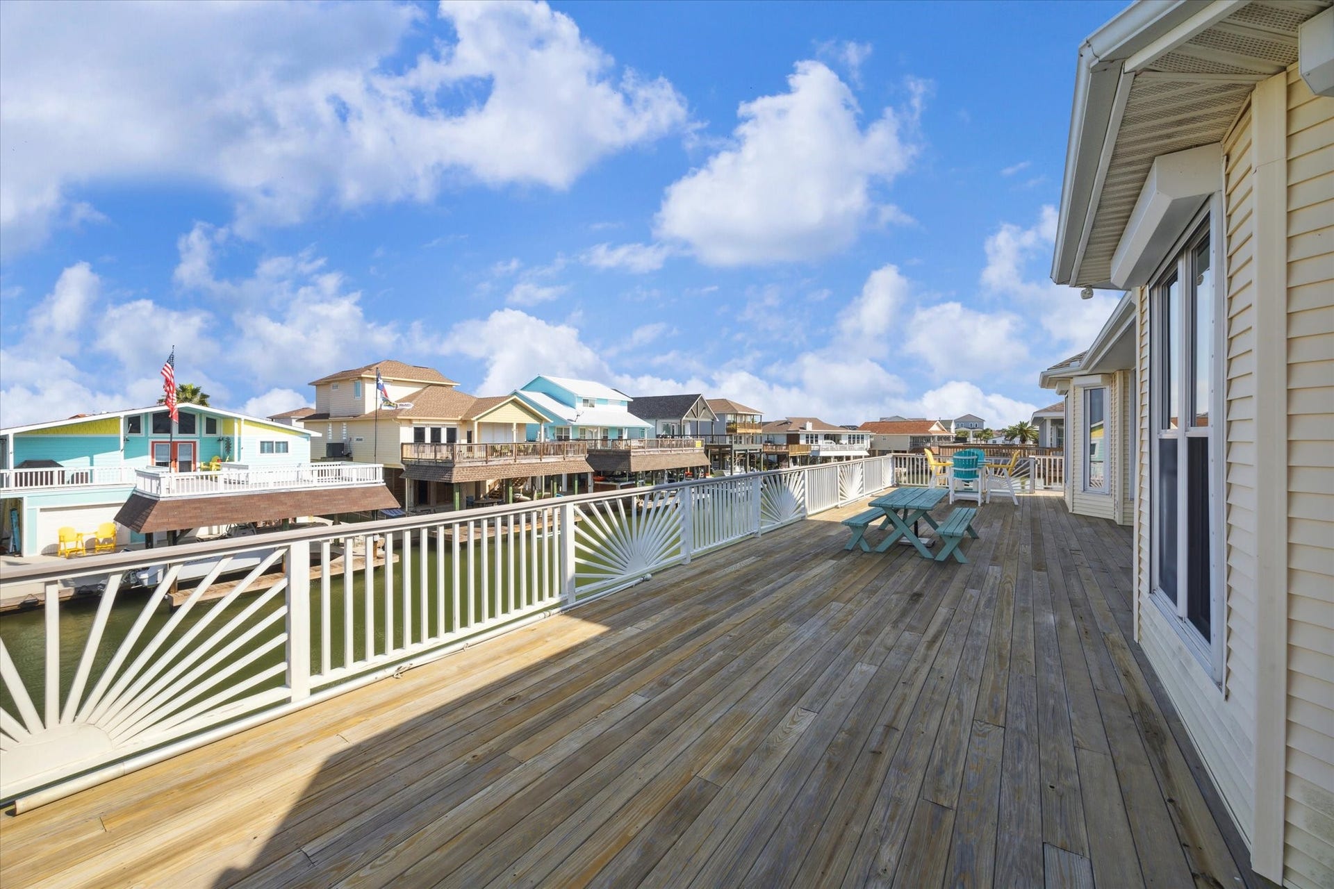 102 Bamaku Bend, Tiki Island, TX 77554 Off of the living room is access to your second level deck that expands across the back of the whole home. The deck was updated with treated wood, Trex railing and custom sunburst details. There is plenty of space to dine, relax and enjoy the views overlooking the water.