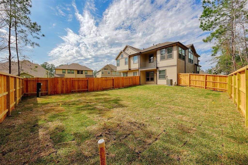 115 Handley Drive, Montgomery, TX 77316 Rear view of the townhome ground level patio and main living are balcony.