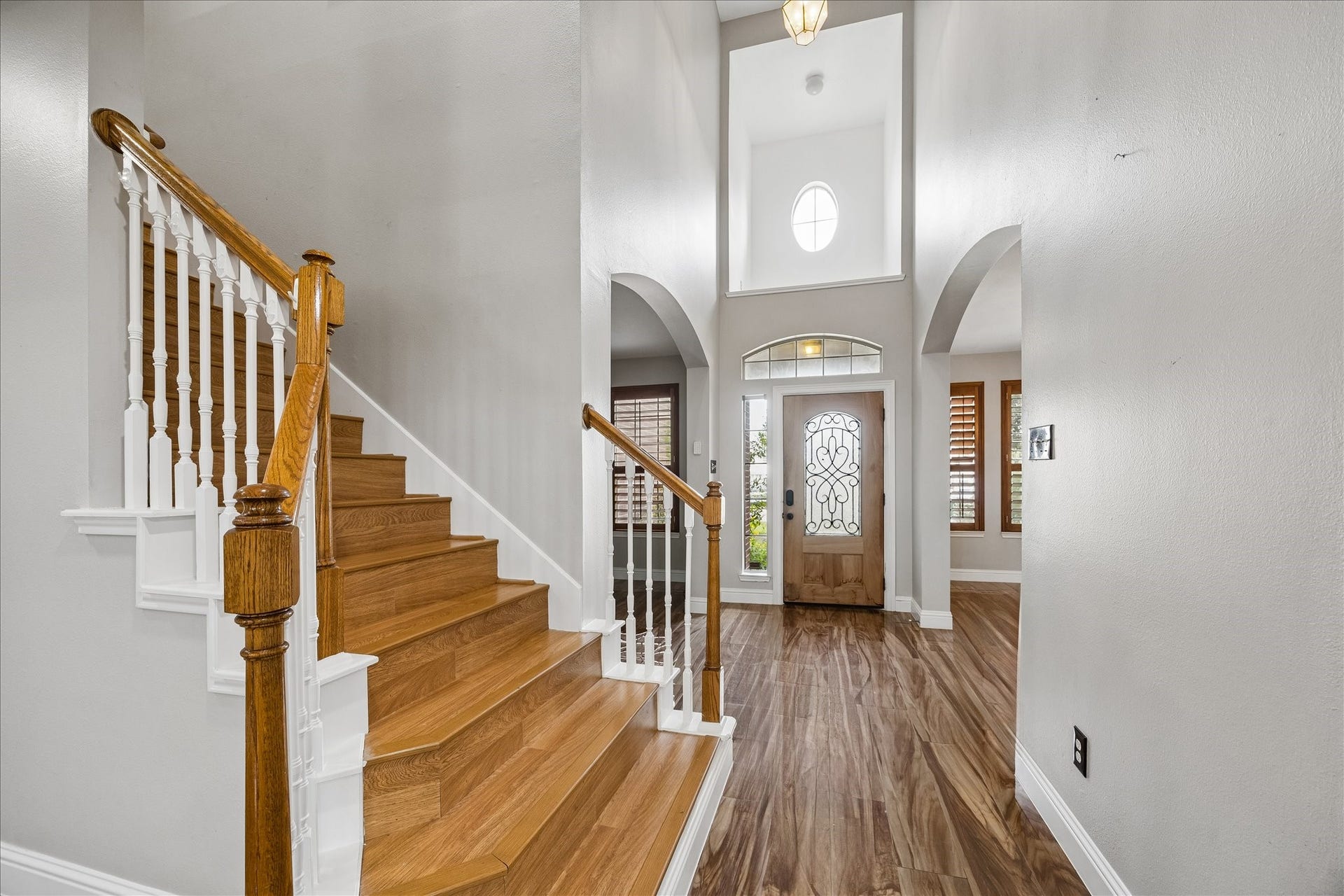 8422 W W Sienna Cove Lane Lane, Houston, TX 77083 Welcoming two-story foyer featuring soaring ceilings, elegant staircase, and beautiful wood-look flooring.