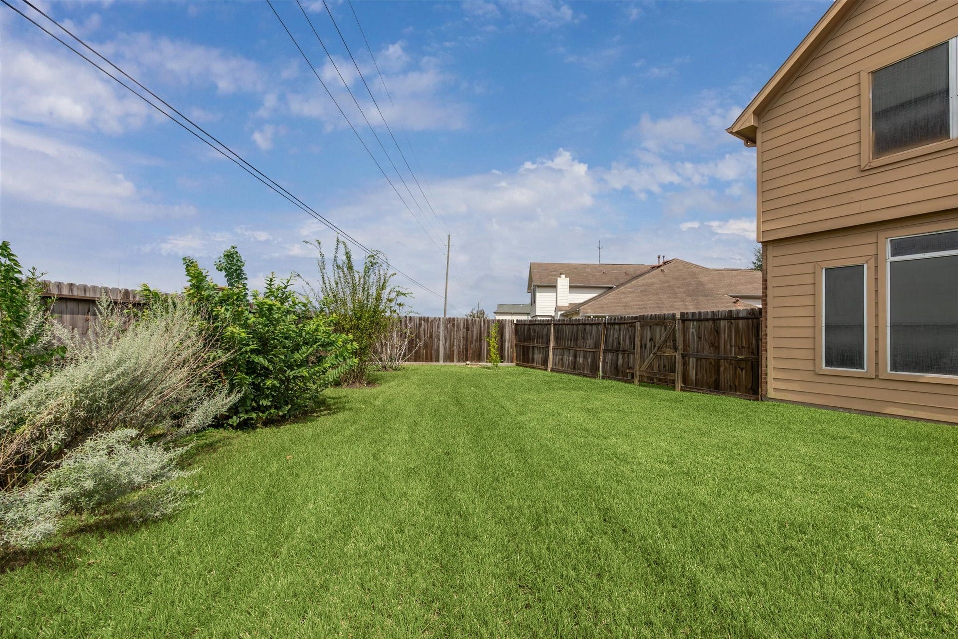 8422 W W Sienna Cove Lane Lane, Houston, TX 77083 Side Yard: Generous side yard featuring a spacious grassy area and privacy fencing.