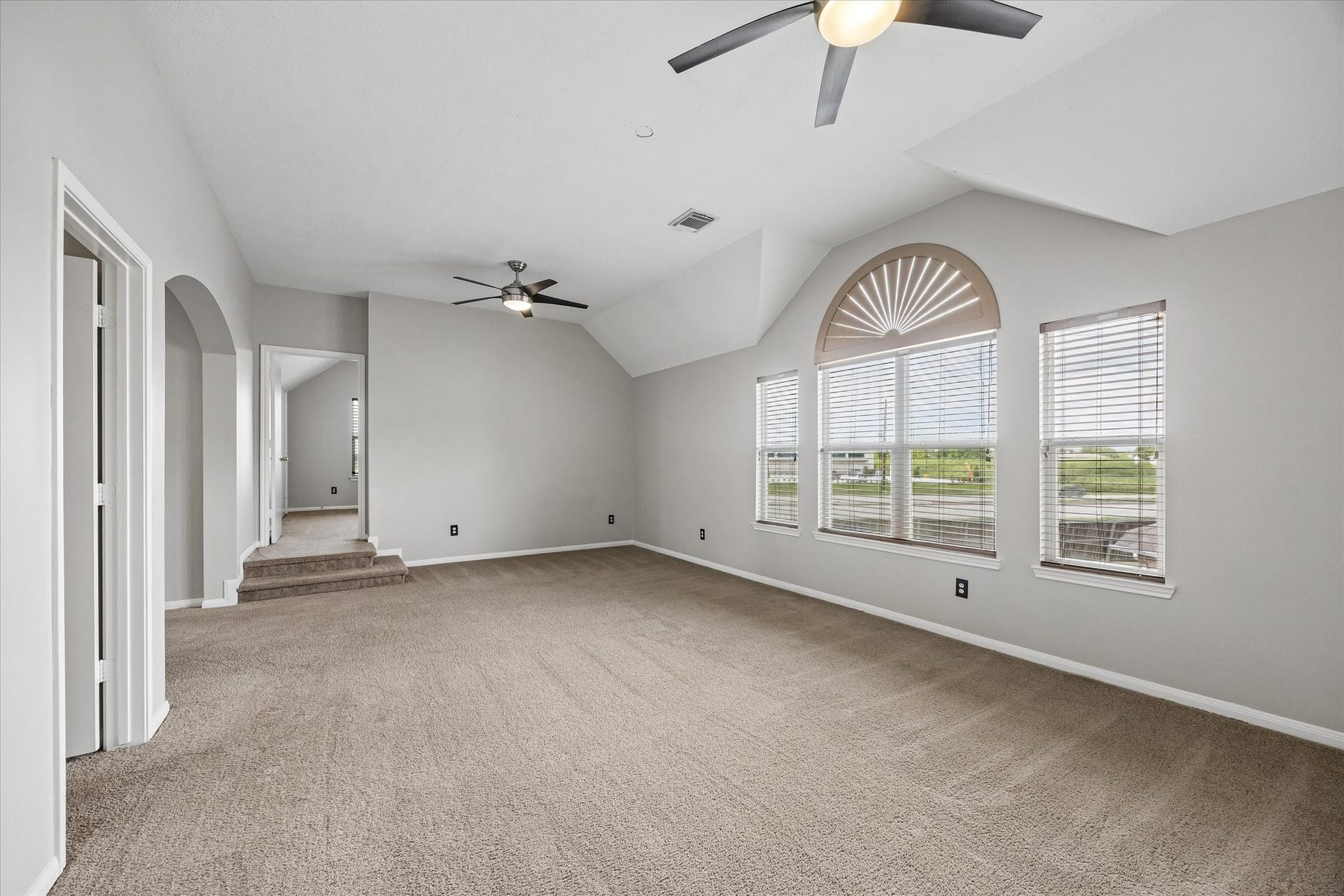 8422 W W Sienna Cove Lane Lane, Houston, TX 77083 Upstairs Game Room: Another view of the spacious second-floor living area featuring vaulted ceilings, ceiling fans, and abundant natural light.