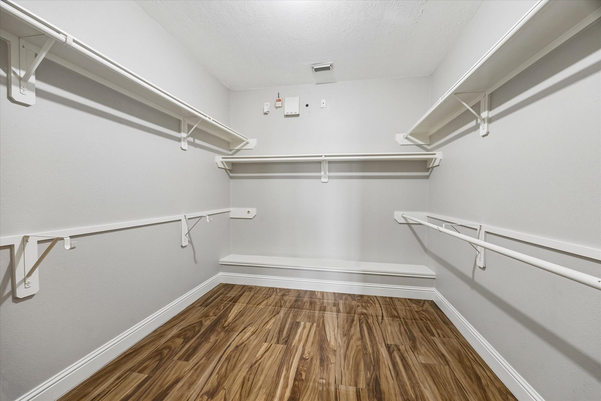 8422 W W Sienna Cove Lane Lane, Houston, TX 77083 Primary Walk-In Closet: Spacious closet featuring built-in shelving, generous hanging space, and wood-look flooring.