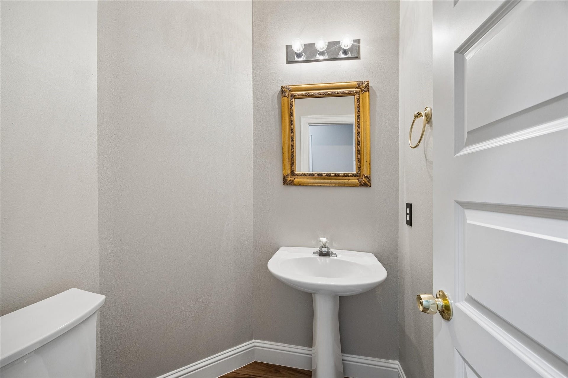 8422 W W Sienna Cove Lane Lane, Houston, TX 77083 Downstairs Half Bath: Conveniently located powder room featuring a pedestal sink and decorative mirror.
