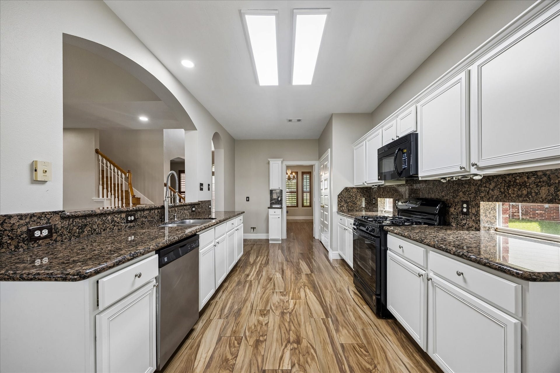 8422 W W Sienna Cove Lane Lane, Houston, TX 77083 Spacious Kitchen: Featuring granite countertops, abundant cabinetry, and a bright, open layout with skylights overhead.