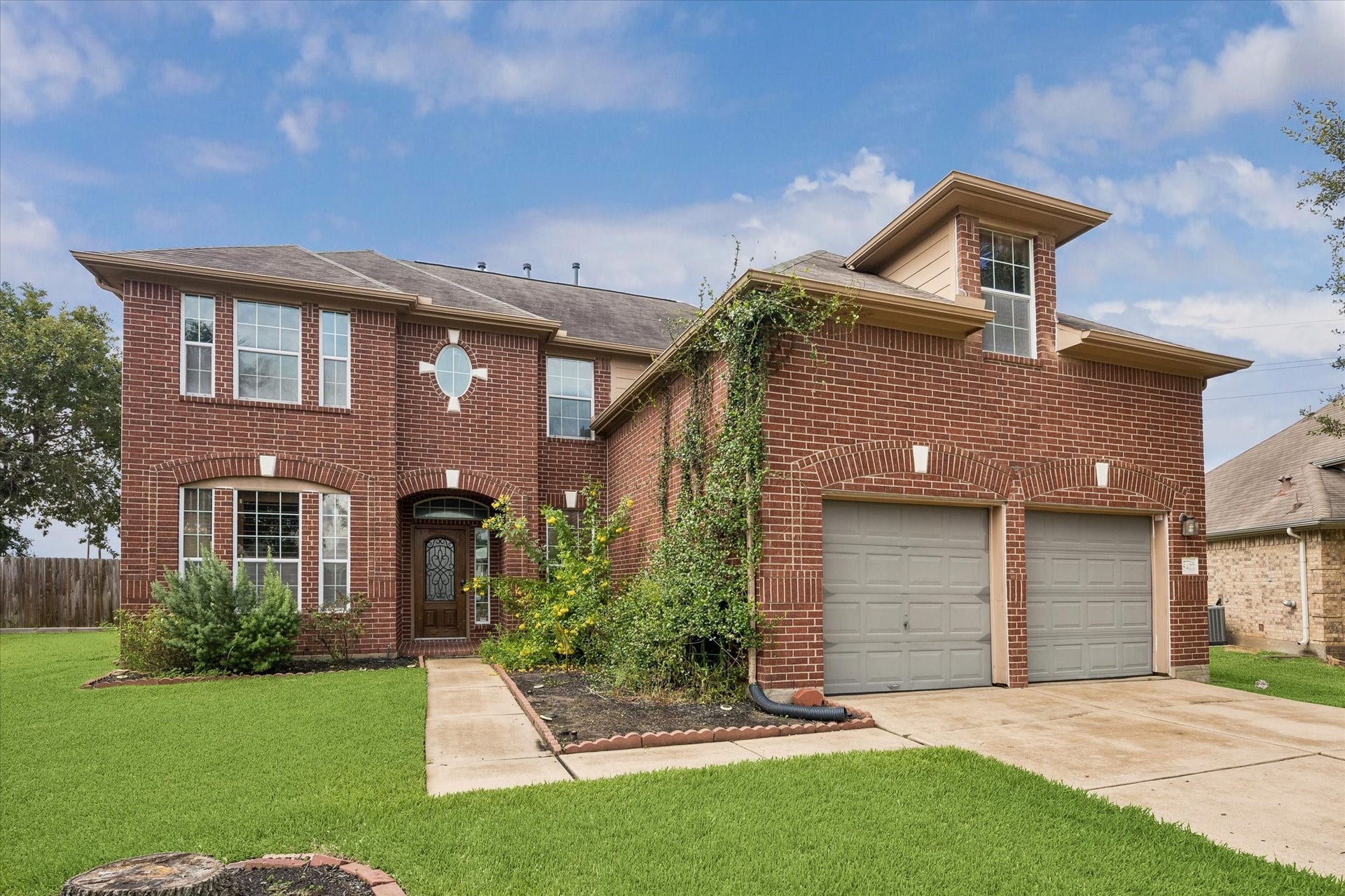 8422 W W Sienna Cove Lane Lane, Houston, TX 77083 Beautiful two-story brick home featuring classic architecture, a two-car garage, and a spacious driveway.