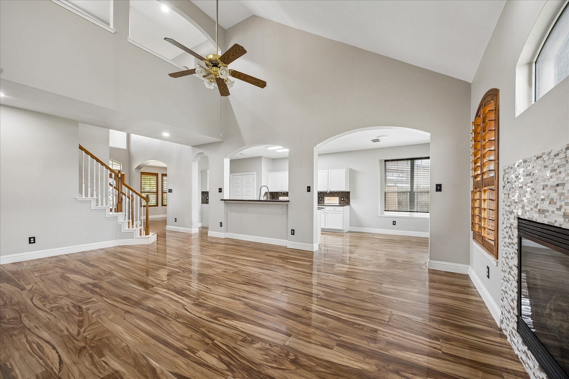8422 W W Sienna Cove Lane Lane, Houston, TX 77083 Open-Concept Family Room: Soaring ceilings, glossy wood-look tile flooring, and a seamless flow into the kitchen and breakfast area.