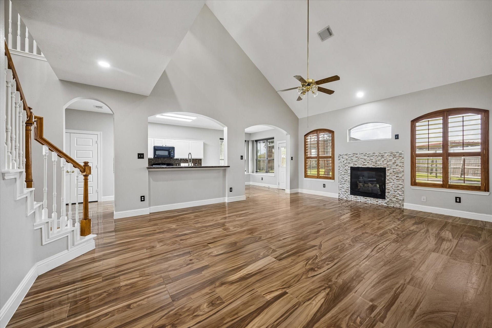 8422 W W Sienna Cove Lane Lane, Houston, TX 77083 Spacious Family Room: Soaring ceilings, beautiful wood-look flooring, abundant natural light, and a cozy fireplace create an inviting living space.