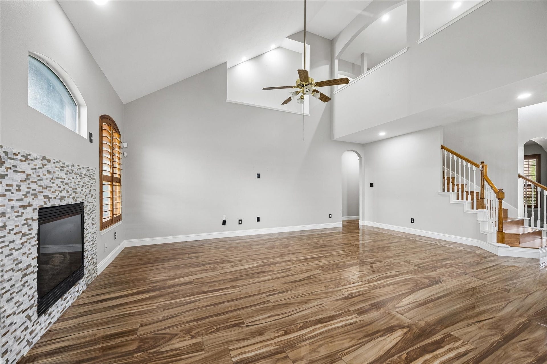 8422 W W Sienna Cove Lane Lane, Houston, TX 77083 Family Room: Another view showcasing the expansive living space, soaring ceilings, beautiful wood-look tile flooring, and open layout.