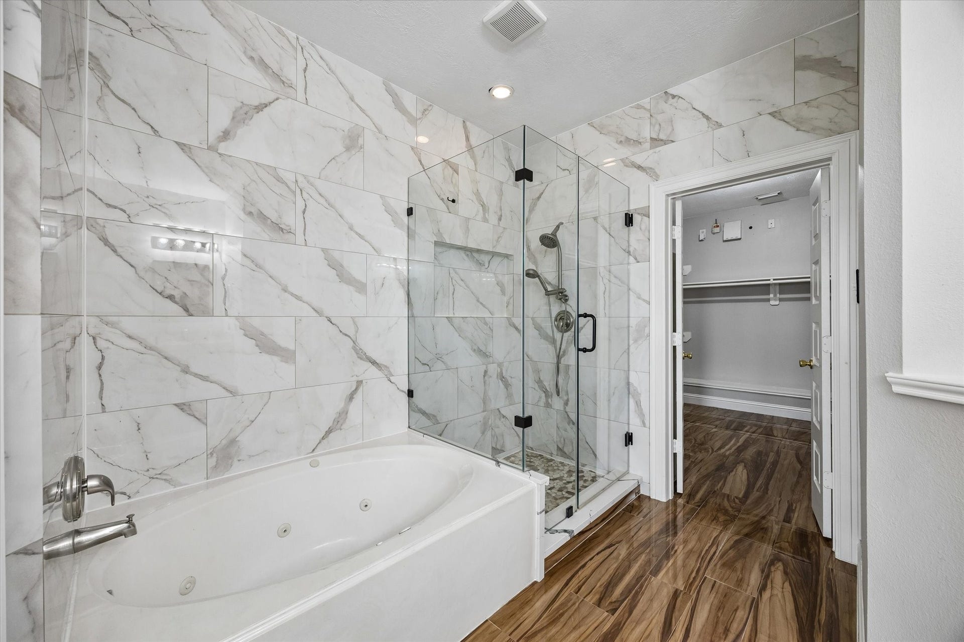 8422 W W Sienna Cove Lane Lane, Houston, TX 77083 Primary Bathroom: Elegant walk-in shower featuring marble-look tile, glass enclosure, and modern fixtures.
