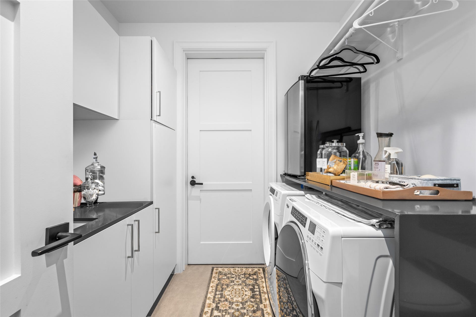 6017 Memorial, #202, Houston, TX 77007 Equipped with a Whirlpool washer and dryer, a sink with gray quartz counters, a hanging rack, generous storage space,
and a conveniently positioned backdoor leading directly to the trash chute - This utility room was built with purpose.