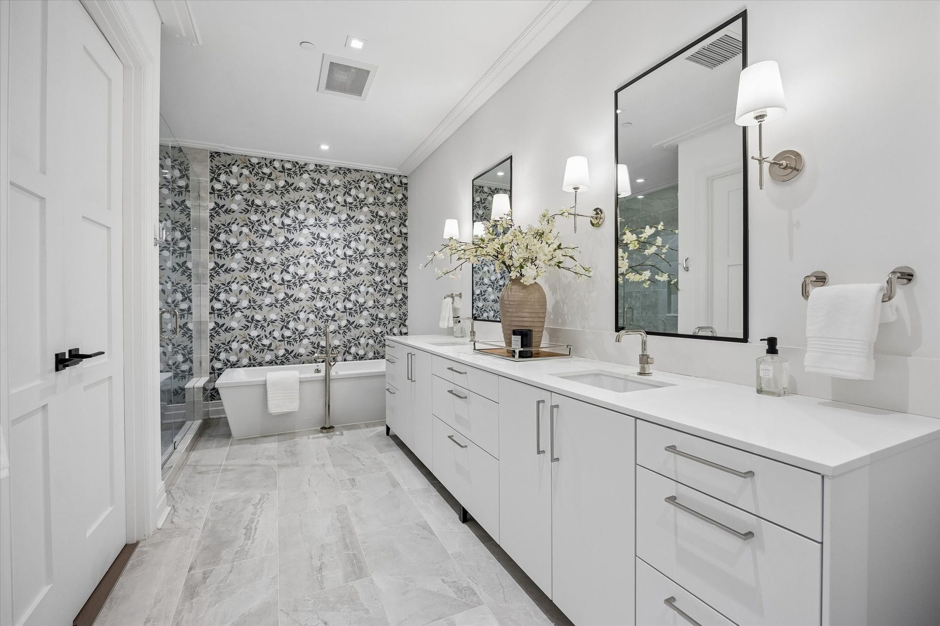 6017 Memorial, #202, Houston, TX 77007 The enormous primary bathroom is a personal sanctuary - adorned with marble floors and tile surround, quartz counters,
white lacquer Siematic cabinetry, and chrome sconces flanking your double sink vanity, This bathroom is a sight to
behold.