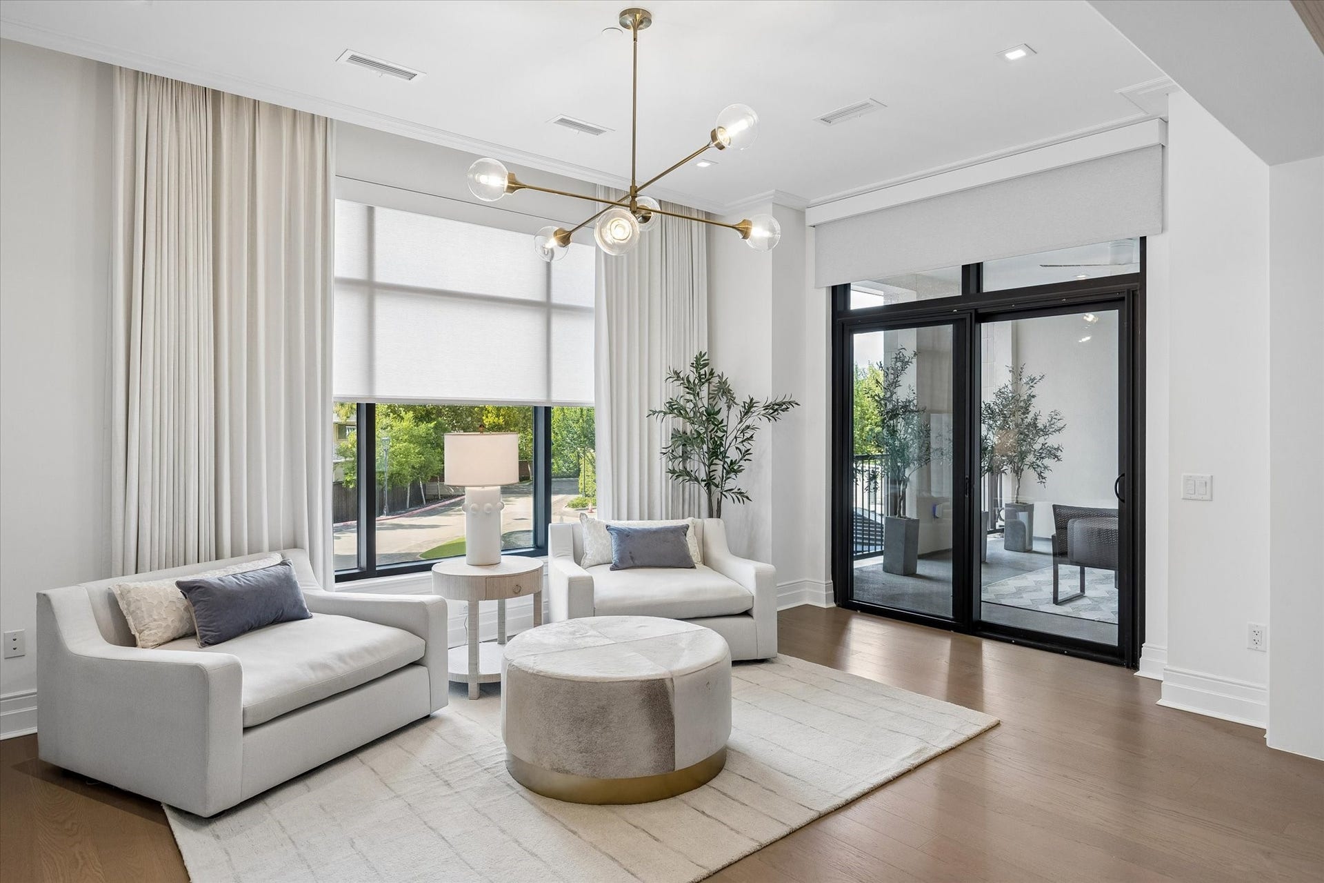 6017 Memorial, #202, Houston, TX 77007 A peaceful seating area offers a comfortable place to unwind, with direct access to the ensuite balcony, while custom blackout draperies and remote-controlled solar shades provide effortless control of light and privacy for a restful nights sleep.