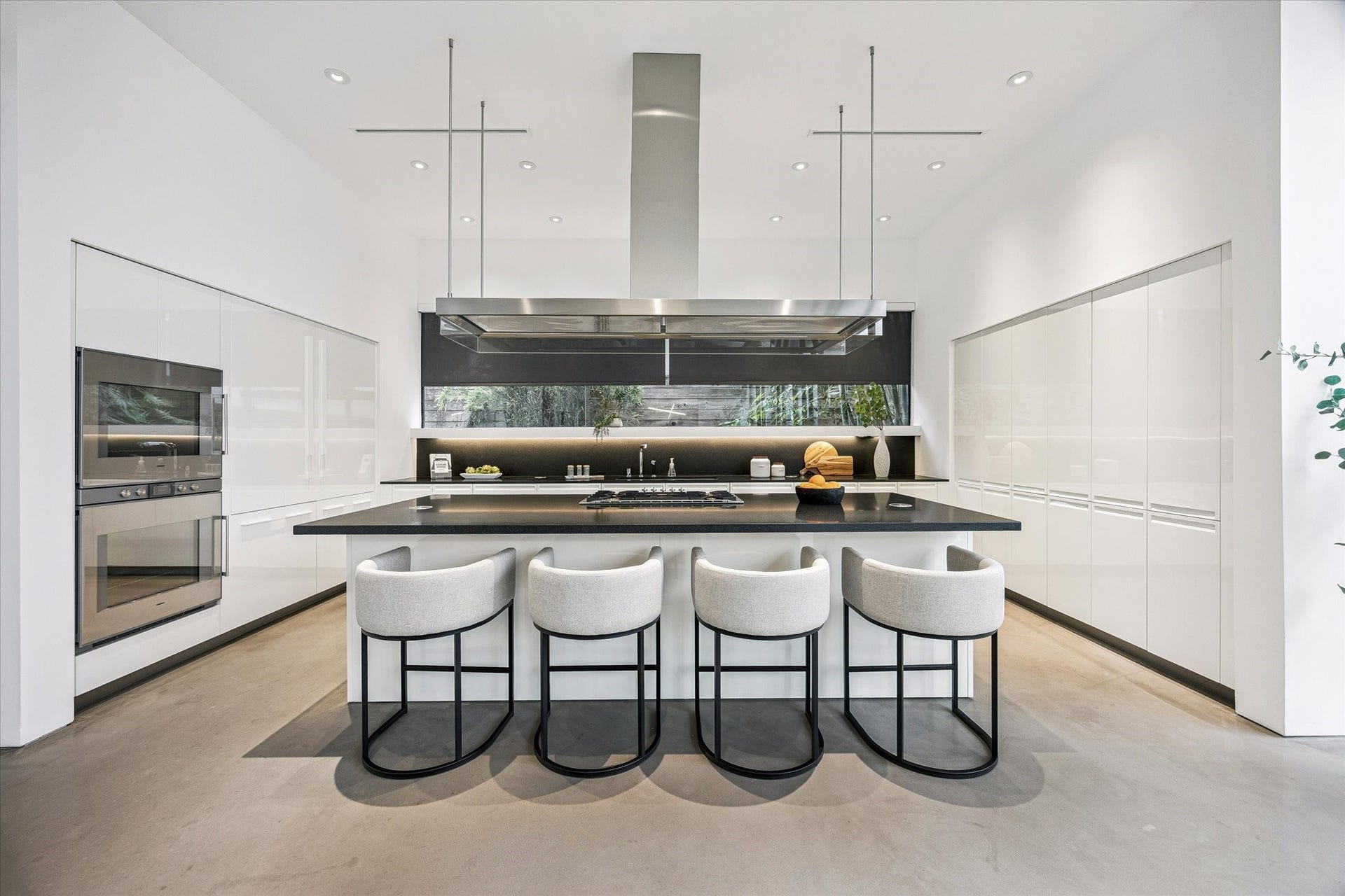 1527 Indiana Street, Houston, TX 77006 The stunning kitchen features premium Gaggenau appliances, and oversized island with seating, integrated storage, and a statement suspended linear vent hood.