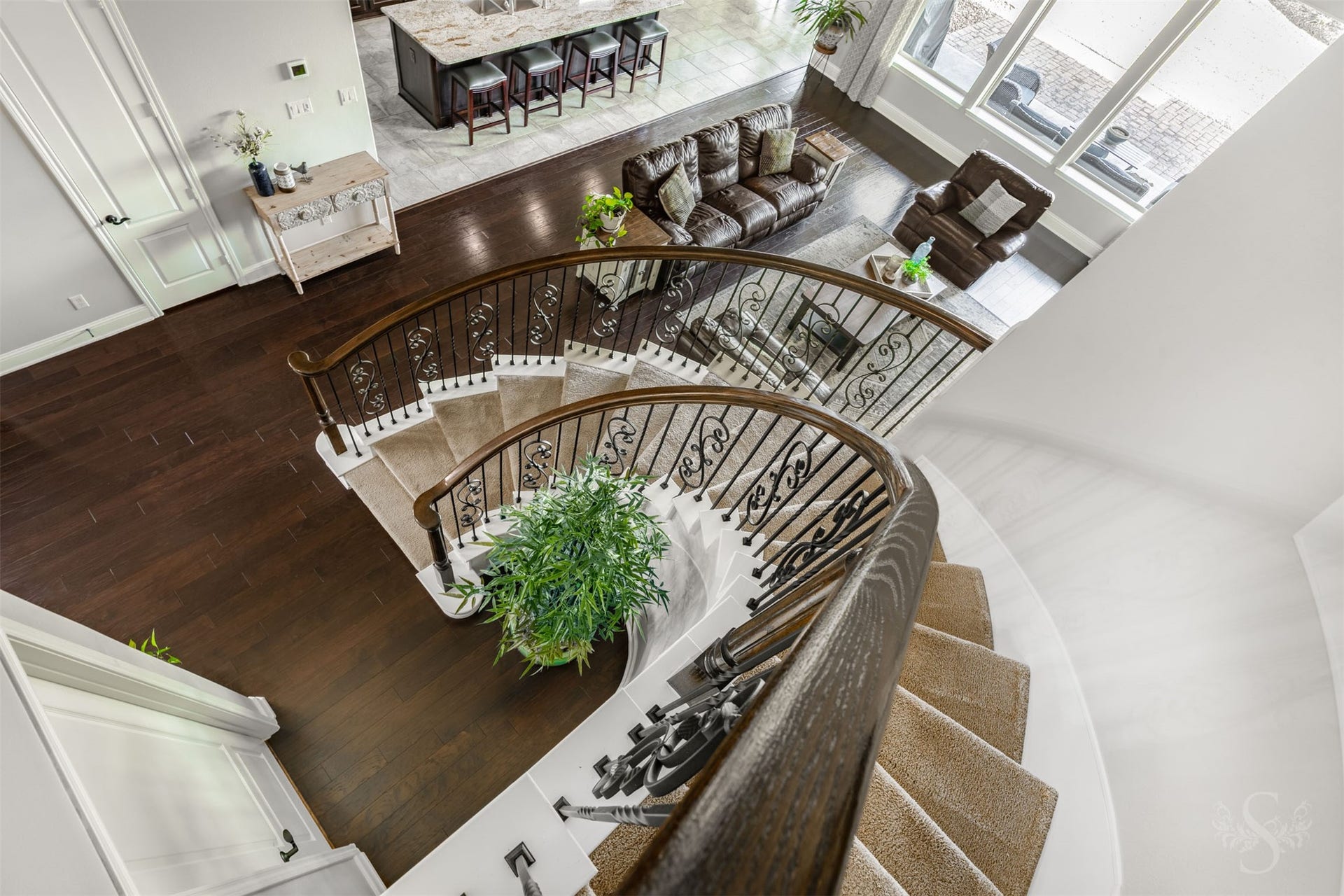 27506 Lakeway Trail Lane, Fulshear, TX 77441 A spectacular view from above captures the sweeping curves of the staircase and the intricate ironwork that make it an architectural showpiece. Rich wood flooring, expansive windows and the open gathering spaces below reveal the homes stunning scale and beauty.