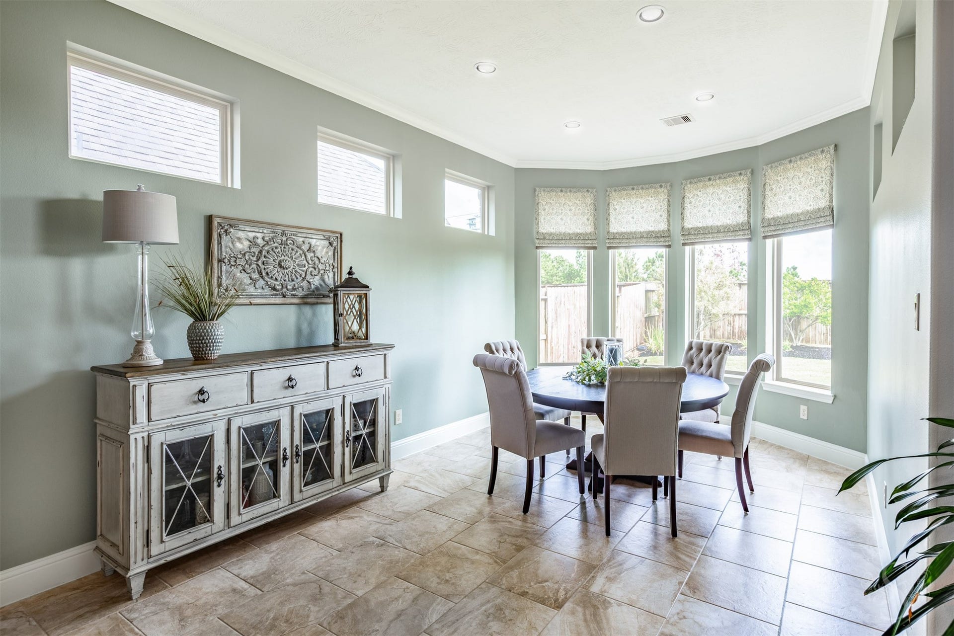 27506 Lakeway Trail Lane, Fulshear, TX 77441 A beautiful bay of tall windows makes this bright and cheerful breakfast room a delightful place to start the day. Enjoy your morning coffee and breakfast with backyard views, surrounded by soft green walls, elegant crown molding and beautiful tile flooring.