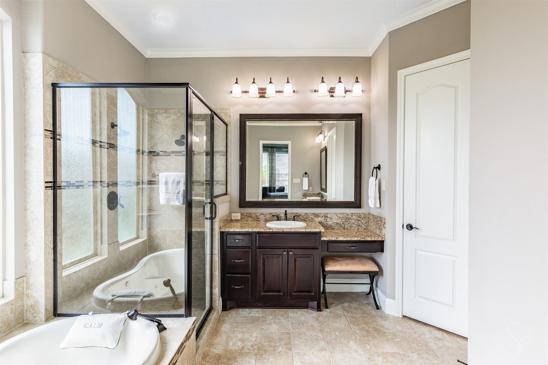27506 Lakeway Trail Lane, Fulshear, TX 77441 A granite-topped vanity with a seated dressing area offers a beautiful place to begin your day. The adjacent glass-enclosed shower features decorative tile accents that complement the baths warm finishes.