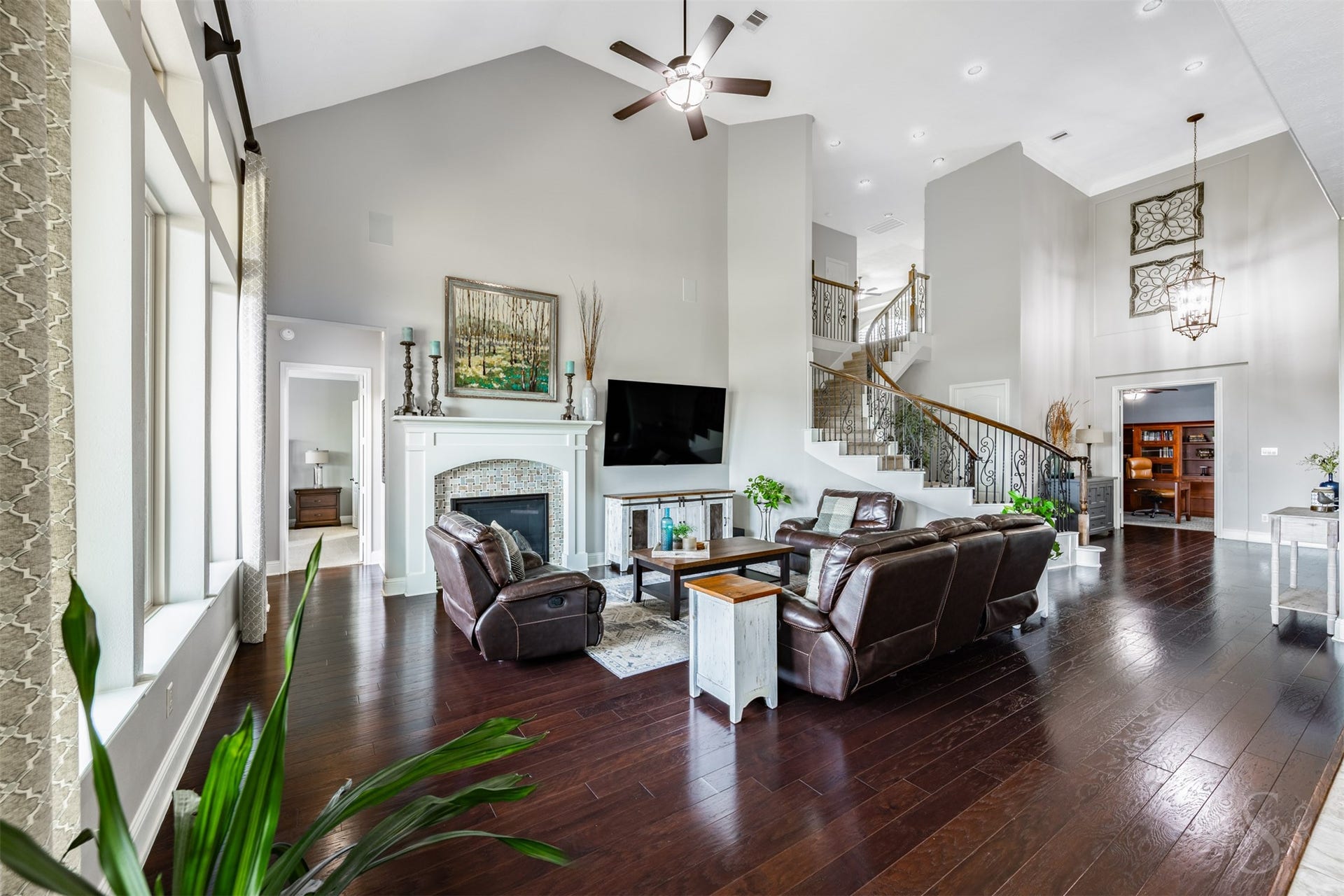 27506 Lakeway Trail Lane, Fulshear, TX 77441 An impressive vaulted ceiling and rich wood flooring give the family room a luxurious sense of scale. Gather around the elegant fireplace or entertain friends in this expansive space, with the curved staircase creating a striking backdrop.