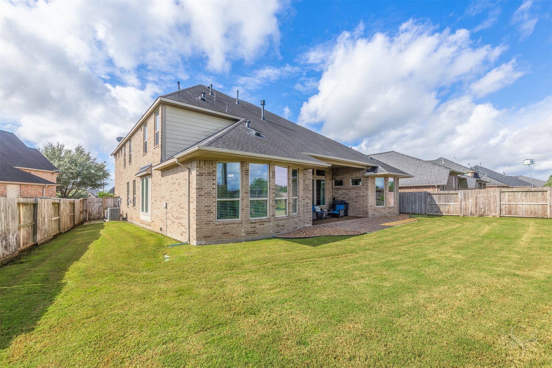 27506 Lakeway Trail Lane, Fulshear, TX 77441 An expansive lawn wraps around the home, providing abundant space for outdoor games, gardening and family fun. The covered patio and adjoining paver extension offer a welcoming setting for relaxed evenings and weekend entertaining.