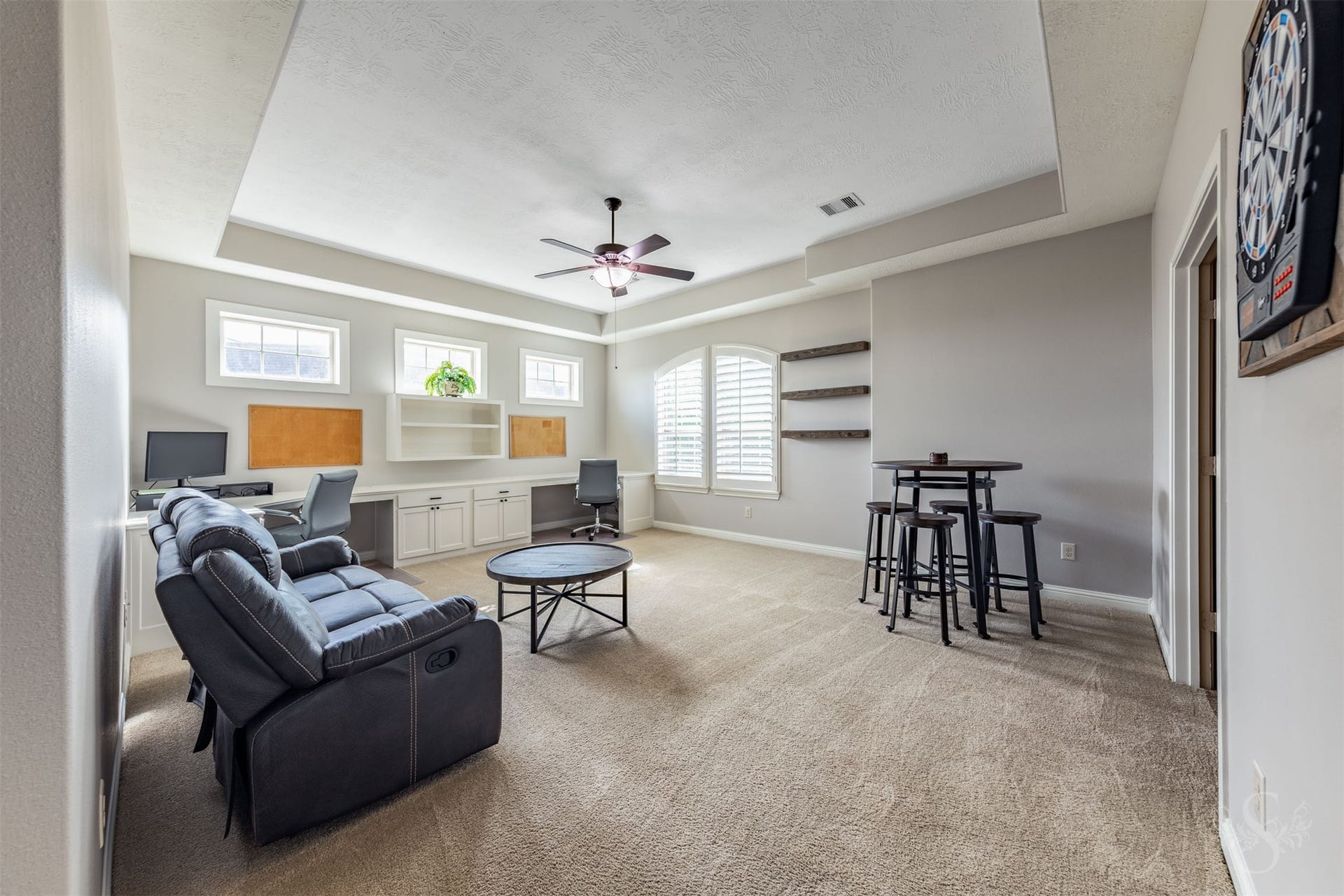 27506 Lakeway Trail Lane, Fulshear, TX 77441 A striking tray ceiling and arched window with plantation shutters give the spacious upstairs game room distinctive character. Built-in desks, cabinetry and shelving create a versatile space for homework, creative projects and family fun.