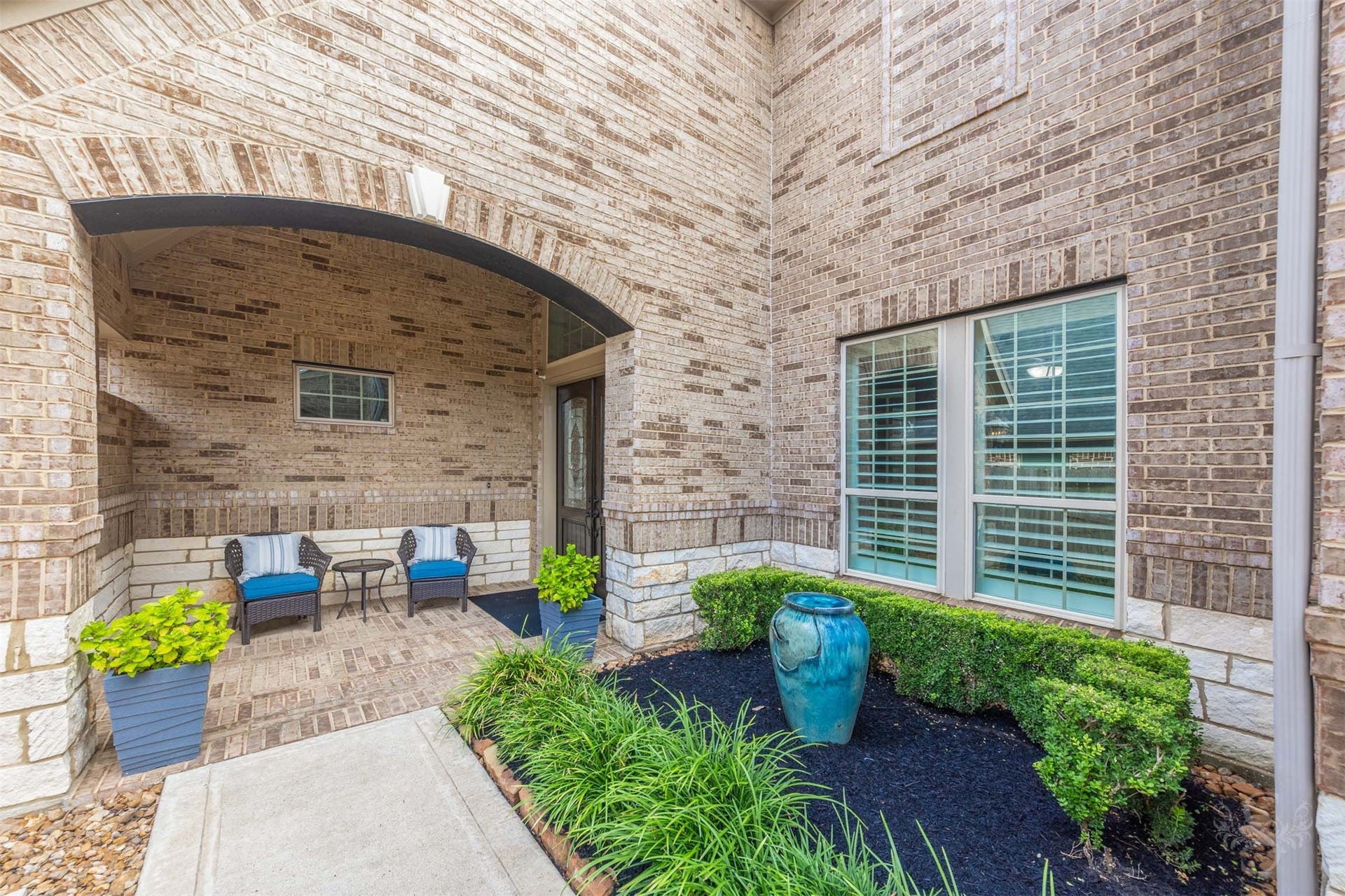 27506 Lakeway Trail Lane, Fulshear, TX 77441 Tucked beneath a graceful brick arch, the sheltered front porch offers an inviting spot for morning coffee or quiet conversation. Brick paving, stone detailing and manicured greenery give this charming courtyard timeless appeal.