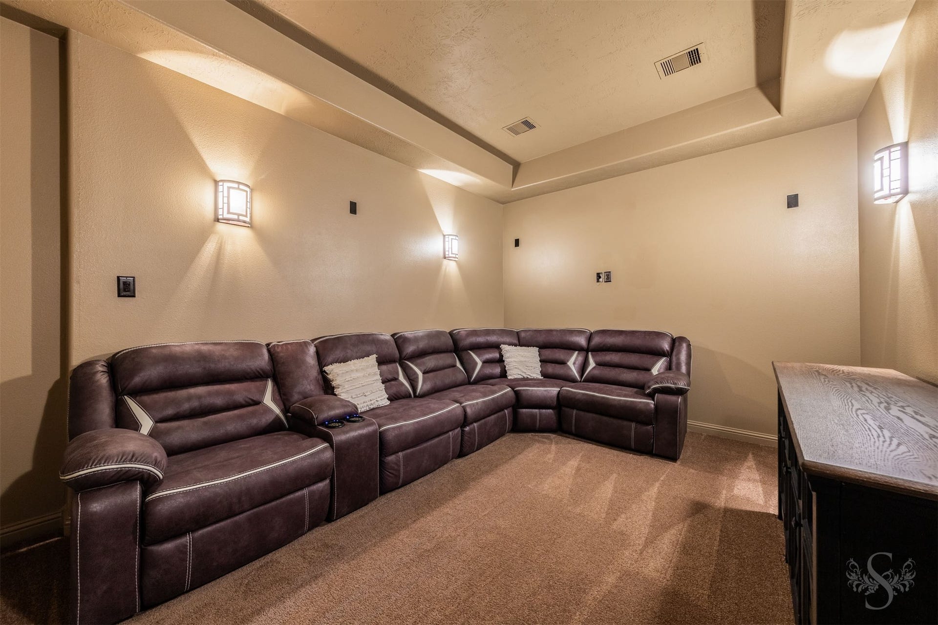27506 Lakeway Trail Lane, Fulshear, TX 77441 Enjoy a cinematic escape in the private media room, featuring a dramatic tray ceiling and softly glowing wall sconces. Plush carpeting and a windowless setting make this inviting retreat perfect for movie nights and watching the big game.
