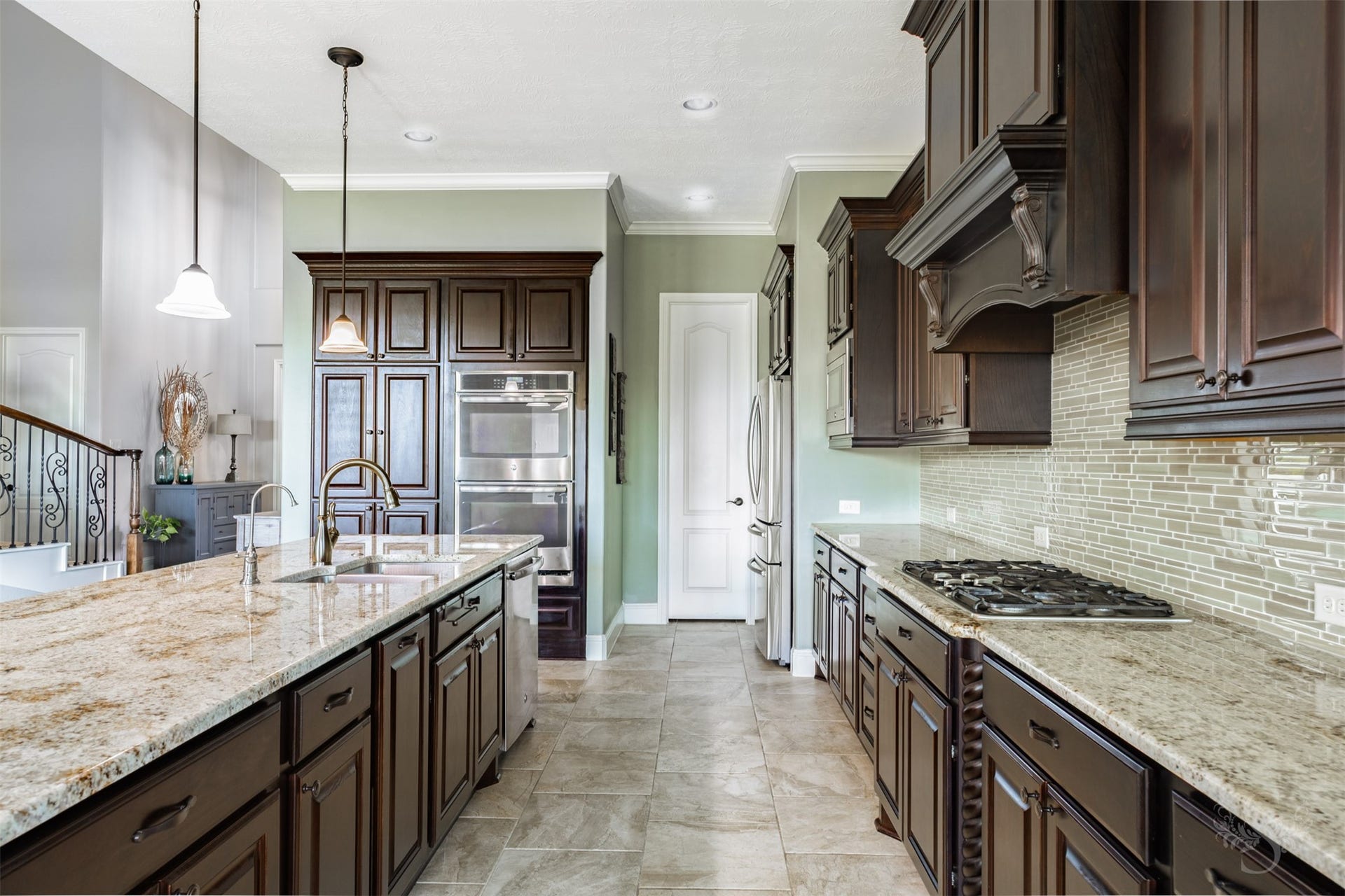 27506 Lakeway Trail Lane, Fulshear, TX 77441 Richly stained cabinetry, expansive granite counters and a decorative wood vent hood give this kitchen timeless elegance. Stainless steel double ovens, a gas cooktop and an island with abundant storage offer a beautiful setting for preparing everything from casual dinners to meals for a crowd.