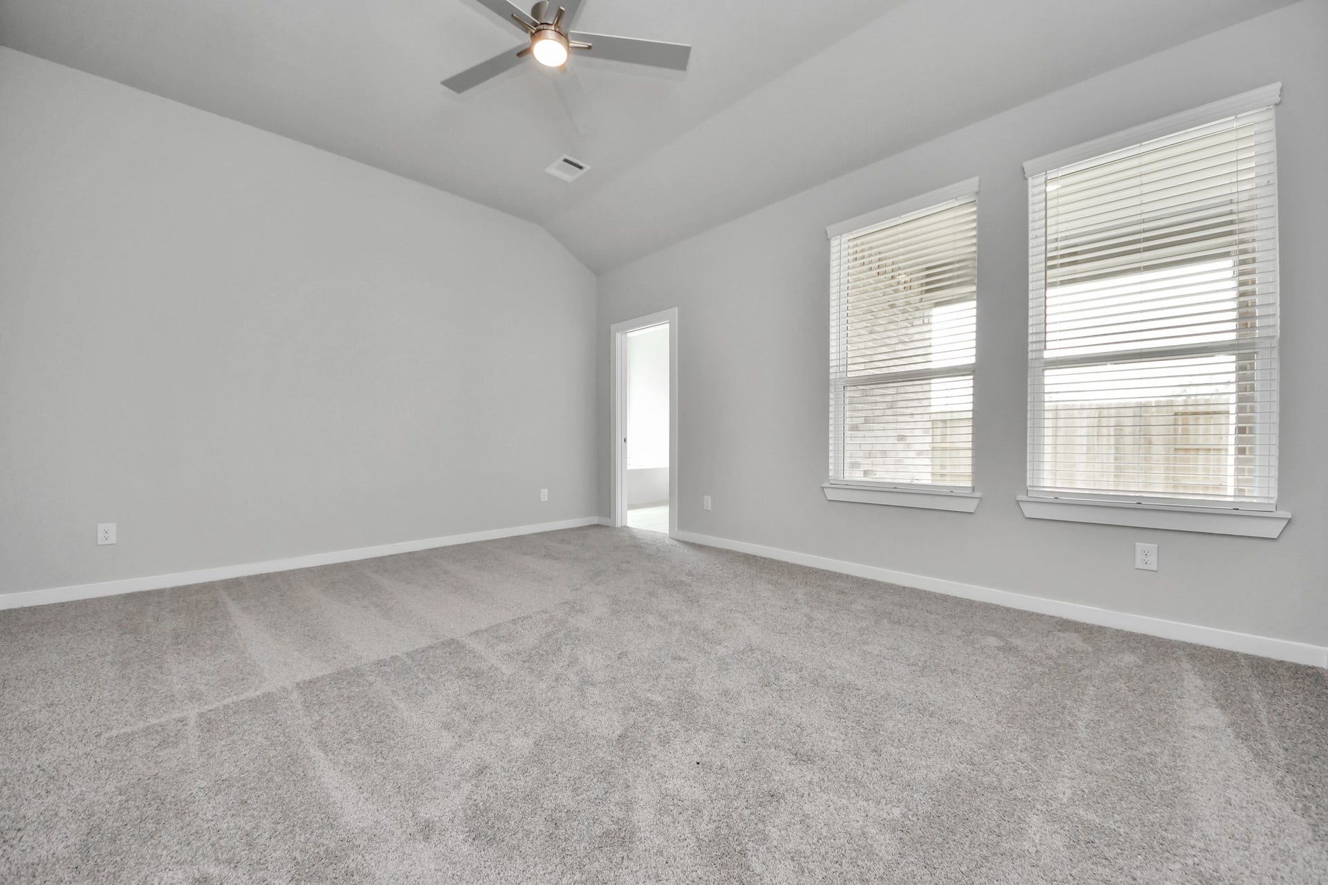Come and unwind after a long day in this magnificent primary suite! This spacious room features plush carpet, warm paint, high ceilings and large windows with privacy blinds. Sample photo of completed home with similar floor plan. Actual colors and selections may vary.