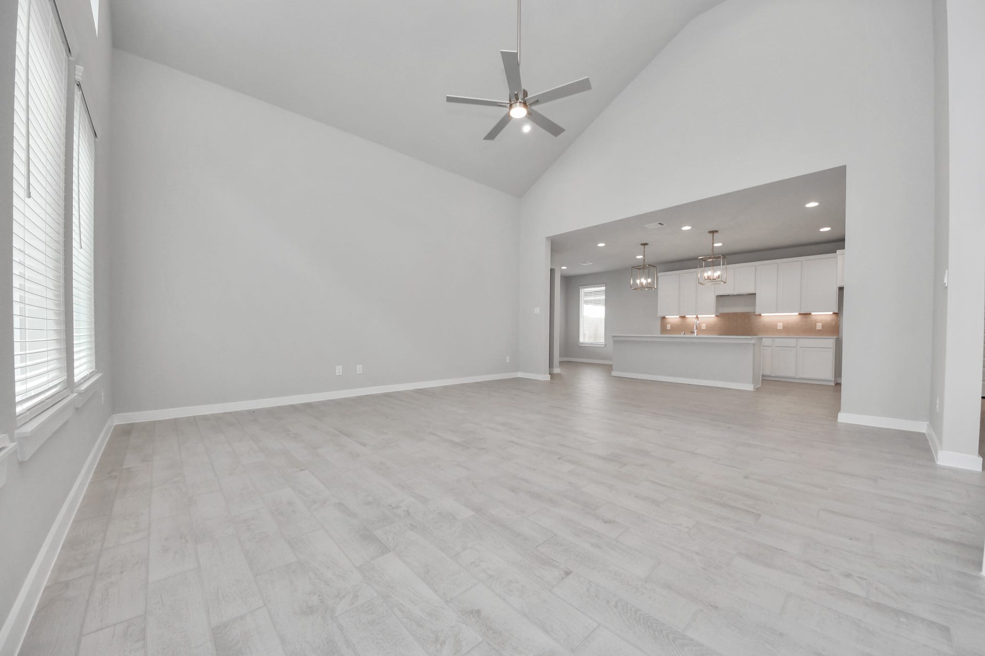 Relax and unwind in this inviting family room, illuminated by abundant natural light streaming in through tall windows, complemented by high ceilings and stunning flooring. Stay comfortable year-round with the gentle breeze from the ceiling fan, creating the perfect atmosphere for family gatherings. Sample photo of completed home with similar floor plan. Actual colors and selections may vary.