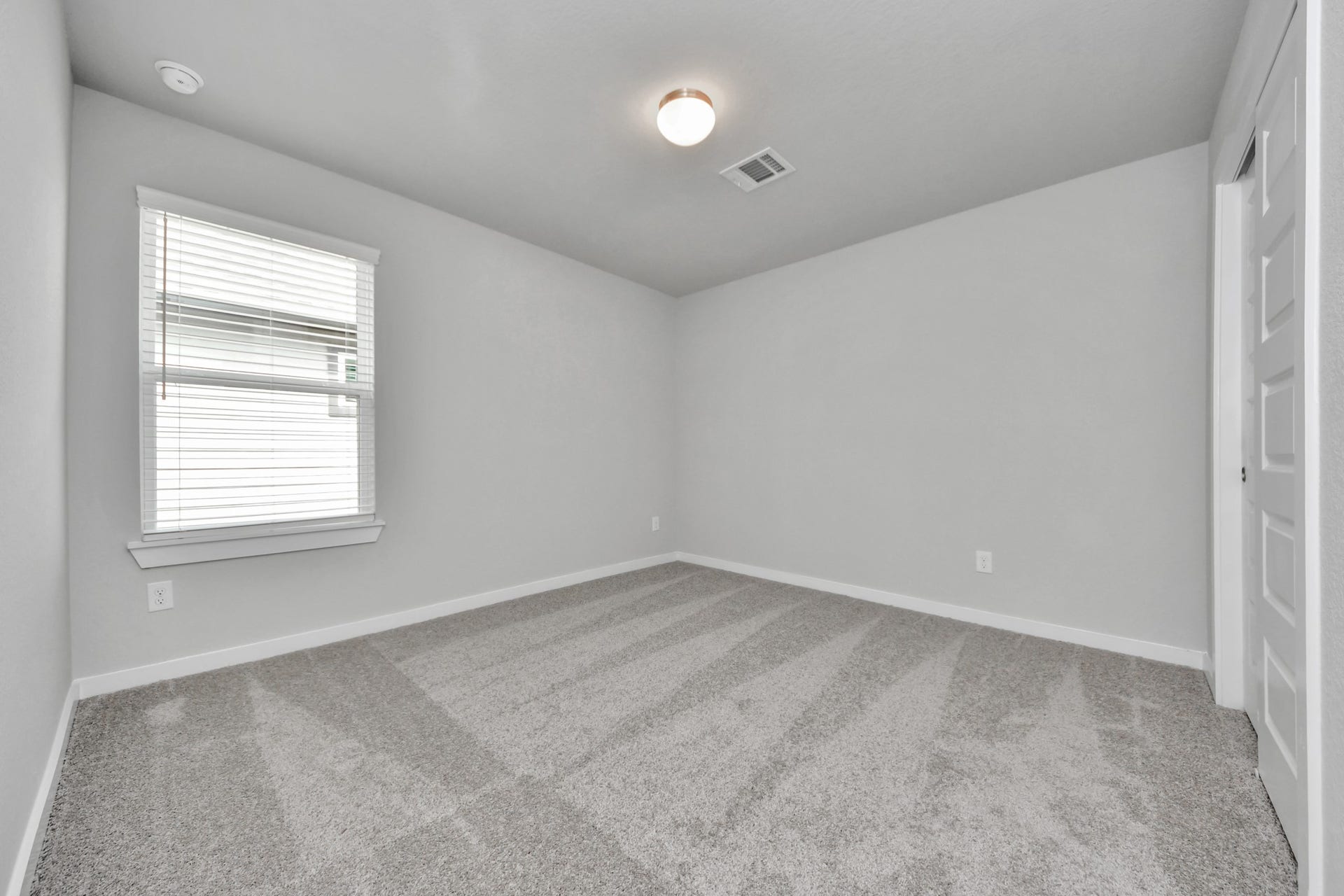 Secondary bedroom features plush carpeting, large windows that let in plenty of natural light, bright paint, and spacious closets. Sample photo of completed home with similar floor plan. Actual colors and selections may vary.
