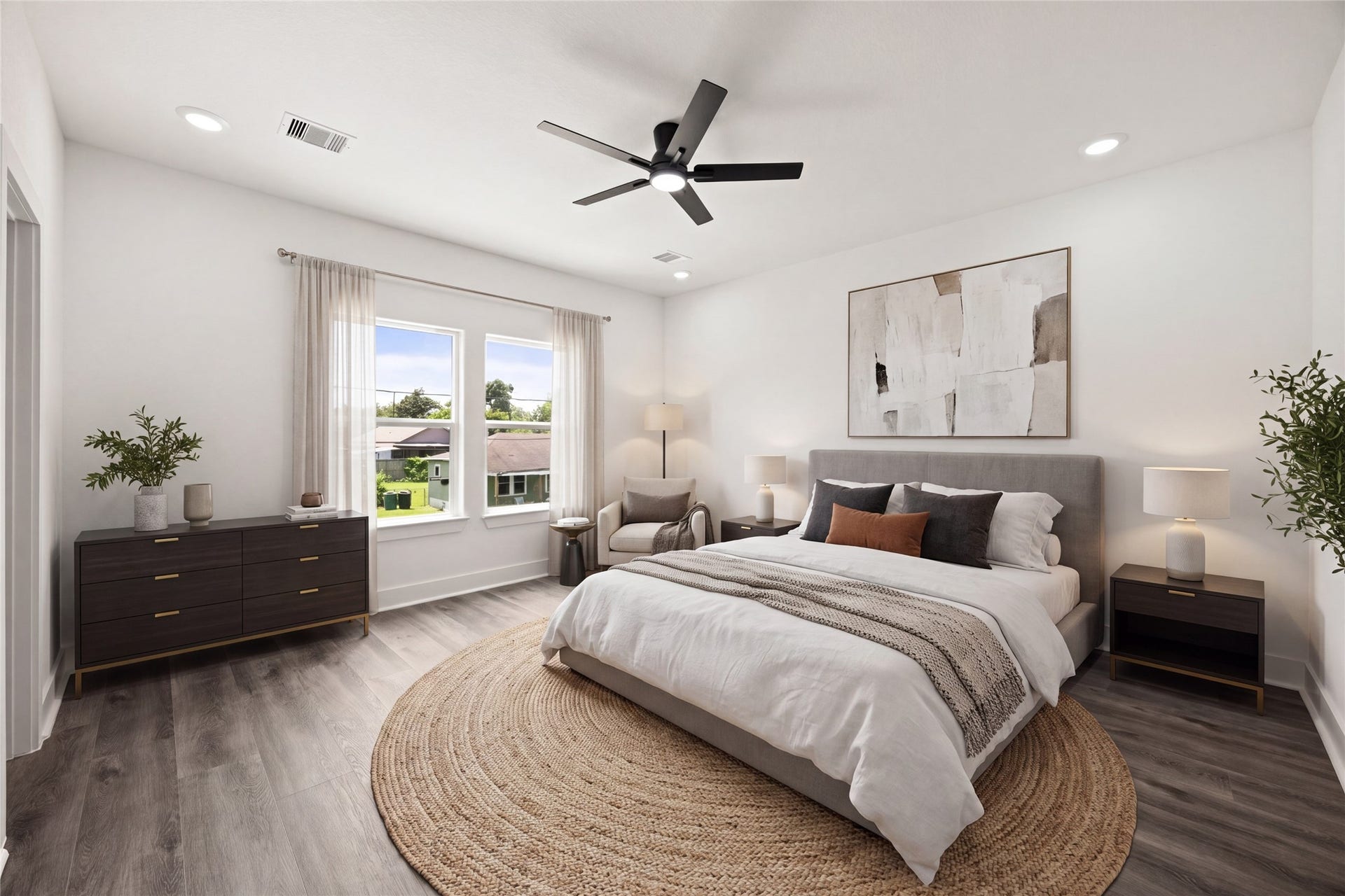 Bright and airy room featuring sleek wood flooring, a modern ceiling fan, and a large window offering plenty of natural light.