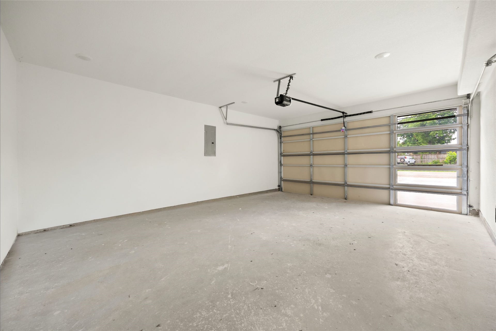 Spacious two-car garage with a modern overhead door, ample storage potential, and easy driveway access.
